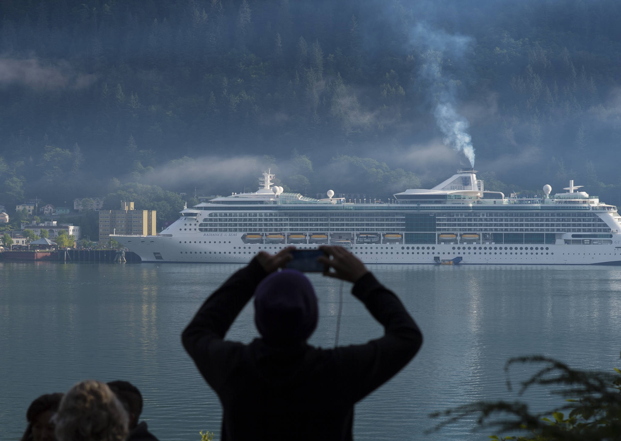 In this Empire file photo, a cruise ship passenger photographs a ship in Juneau’s downtown harbor on August 29, 2017. (Juneau Empire File)