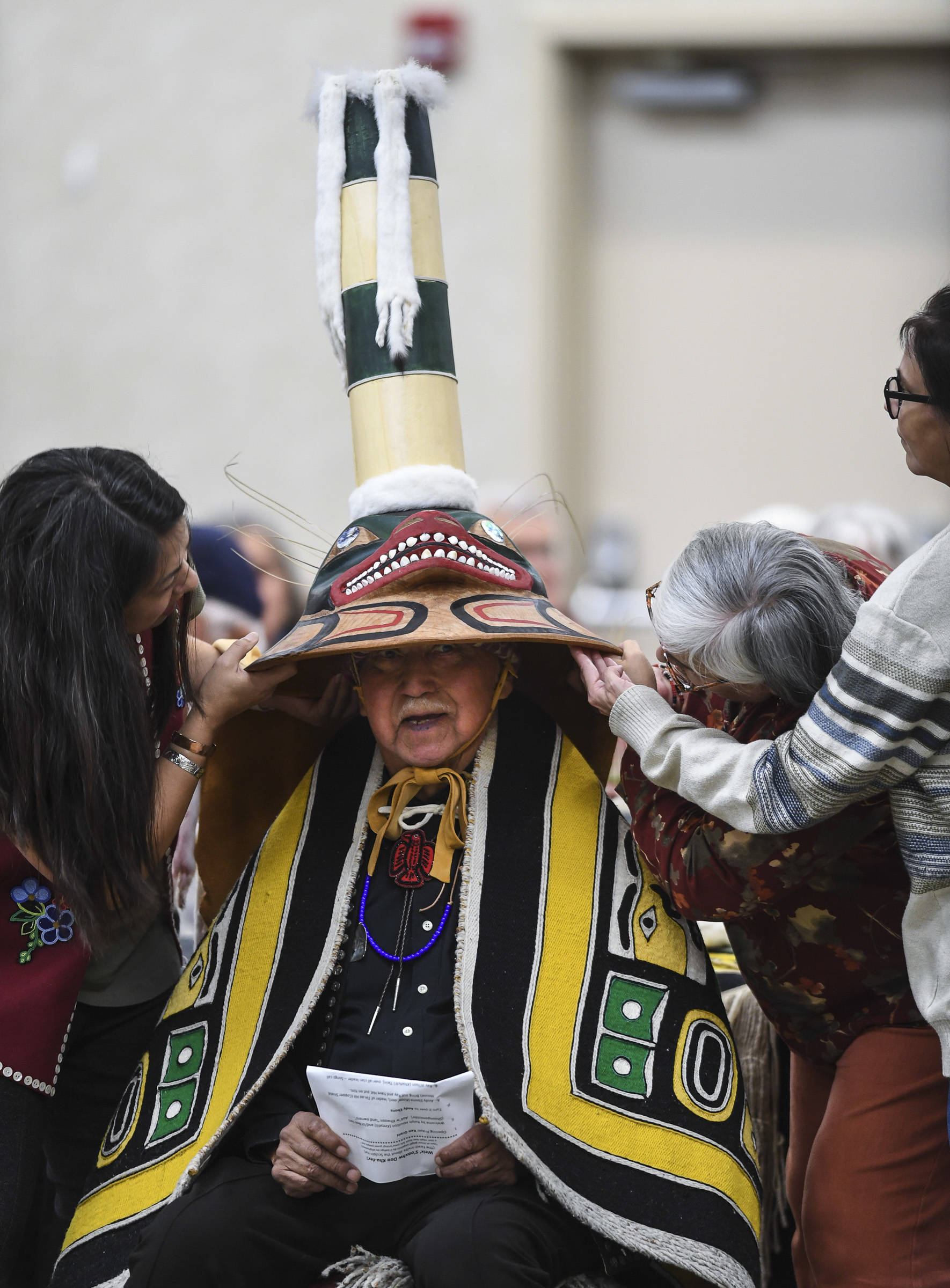Members of the Killer Whale Clan support a replica of a sculpin clan hat on Ray Wilson, clan leader for the Kiks.ádi Clan, during a welcoming ceremony at Elizabeth Peratrovich Hall on Wednesday, Sept. 25, 2019. The original hat was collected from the Kiks.ádi Clan in Sitka in 1884. The Smithsonian Institution used a 3D digitization process to document the hat and constructed the hat using traditional materials. (Michael Penn | Juneau Empire)