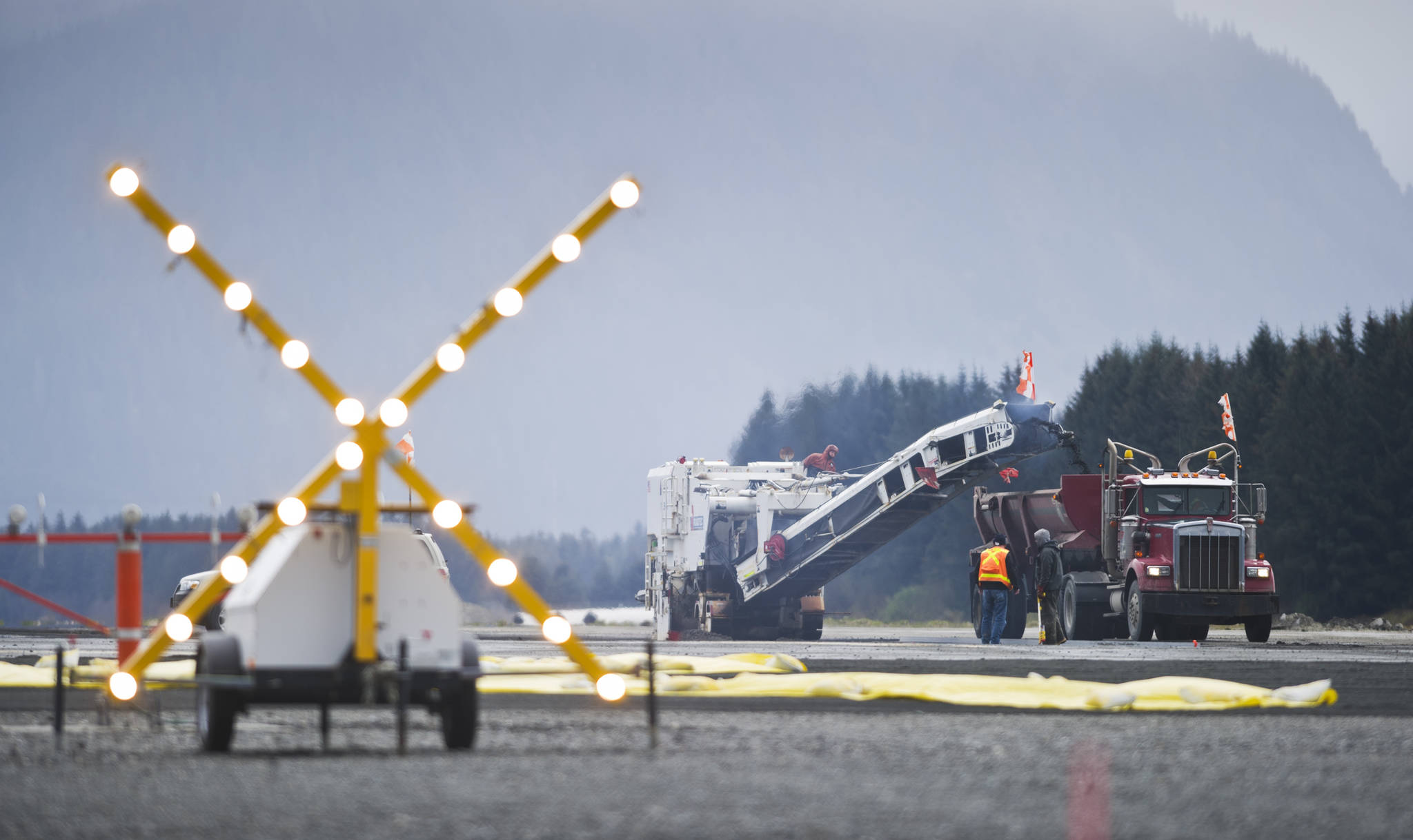 A flashing “X” signals the closed runway as crews work on a repaving project at the Juneau International Airport in 2015. (Michael Penn | Juneau Empire)