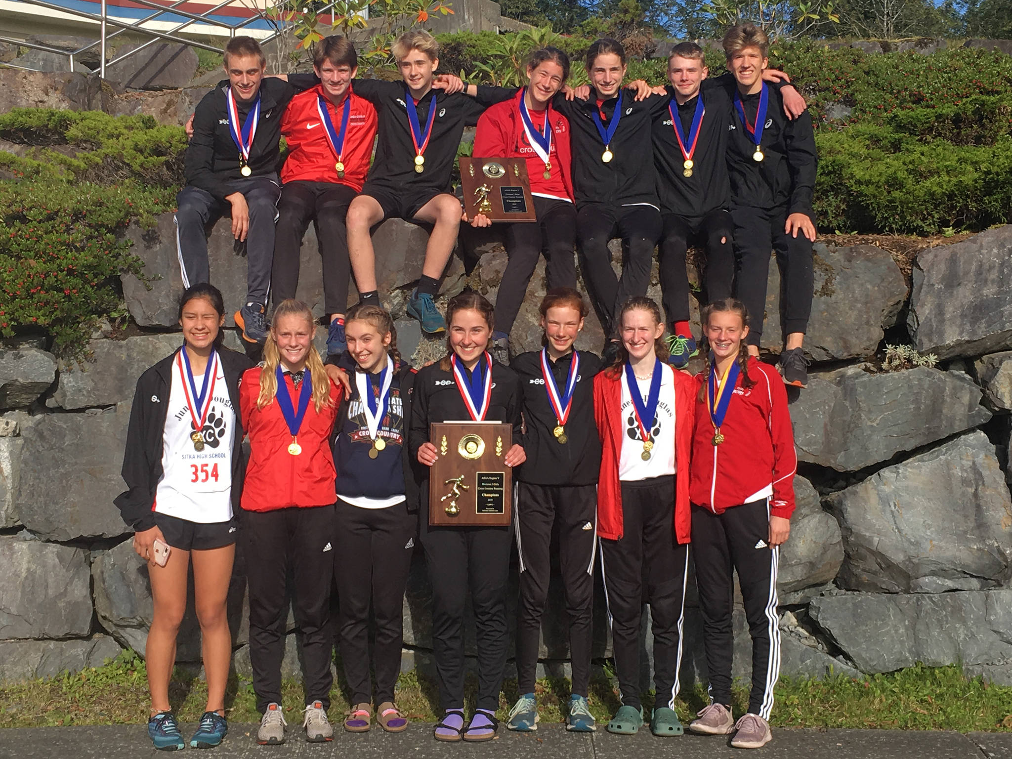 The Juneau-Douglas High School: Yadaat.at Kalé boys and girls varsity cross country teams pose with their Region V Division I championship plaques after sweeping the Region V Cross Country Championships at Sitka National Historical Park on Saturday, Sept. 28, 2019. (Courtesy Photo | Merry Ellefson)