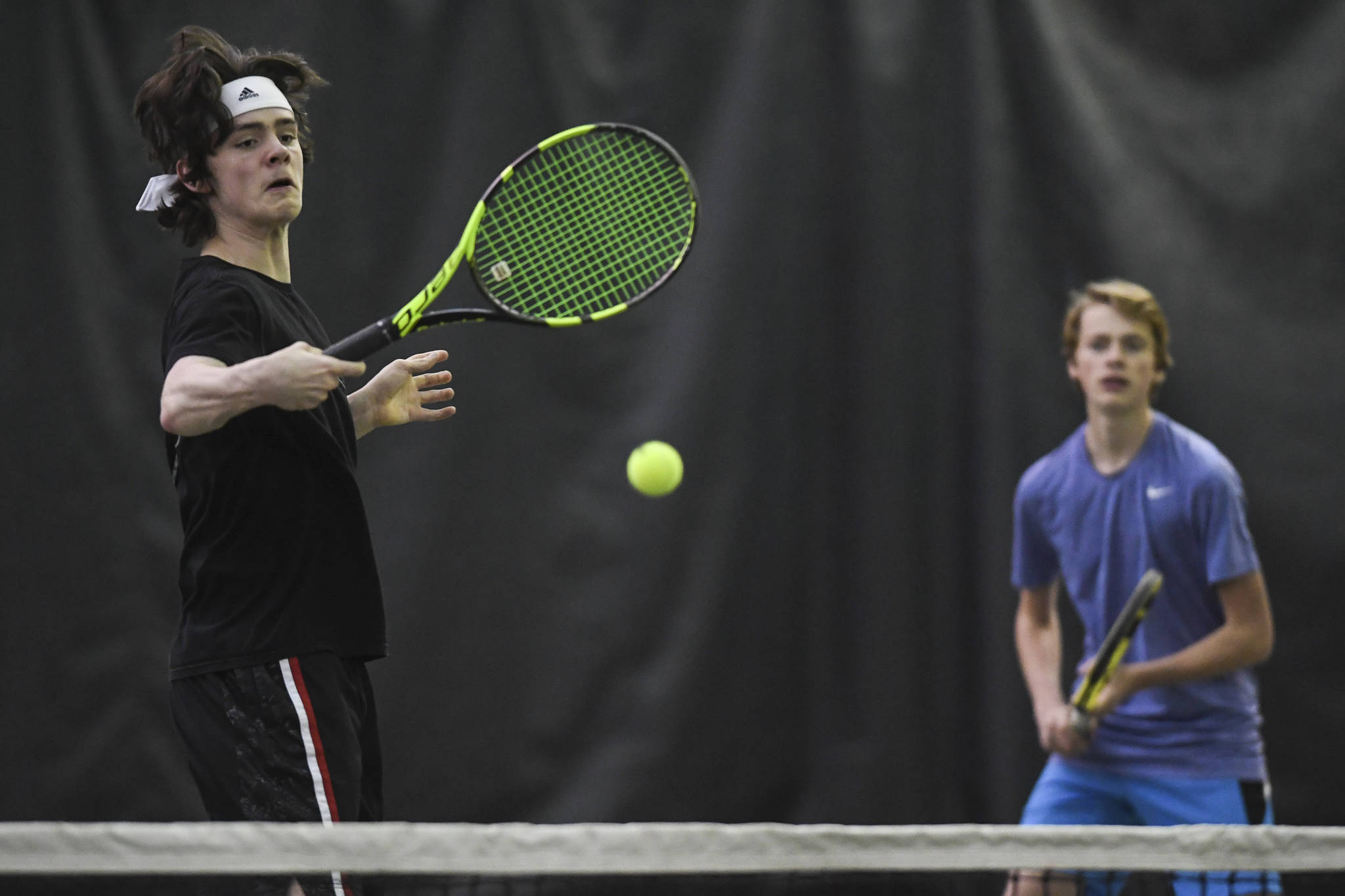 William Smoker, left, volleys in front of his partner, Will Rehfeldt as they play against Luke Bibb and Reed Loree at the Region V Tennis Tournament at the Alaska Club/JRC on Wednesday, Sept. 25, 2019. Smoker and Rehfeldt won the match 6-0, 6-0, and played Liam Penn and Callan Smith in the final on Saturday. (Michael Penn | Juneau Empire)