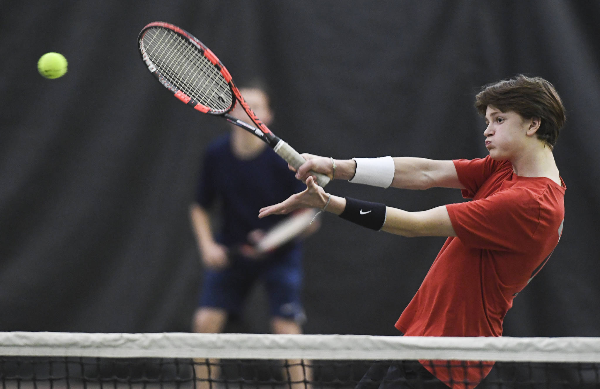 Callan Smith returns a volley as he plays doubles with partner Liam Penn, background, against Kevin Kooistra and Alain Soltys at the Regional Tennis Tournament at the Alaska Club/JRC on Wednesday, Sept. 25, 2019. Penn and Smith won the match 6-2, 6-1, and played Will Rehfeldt and William Smoker in the final on Saturday. (Michael Penn | Juneau Empire)