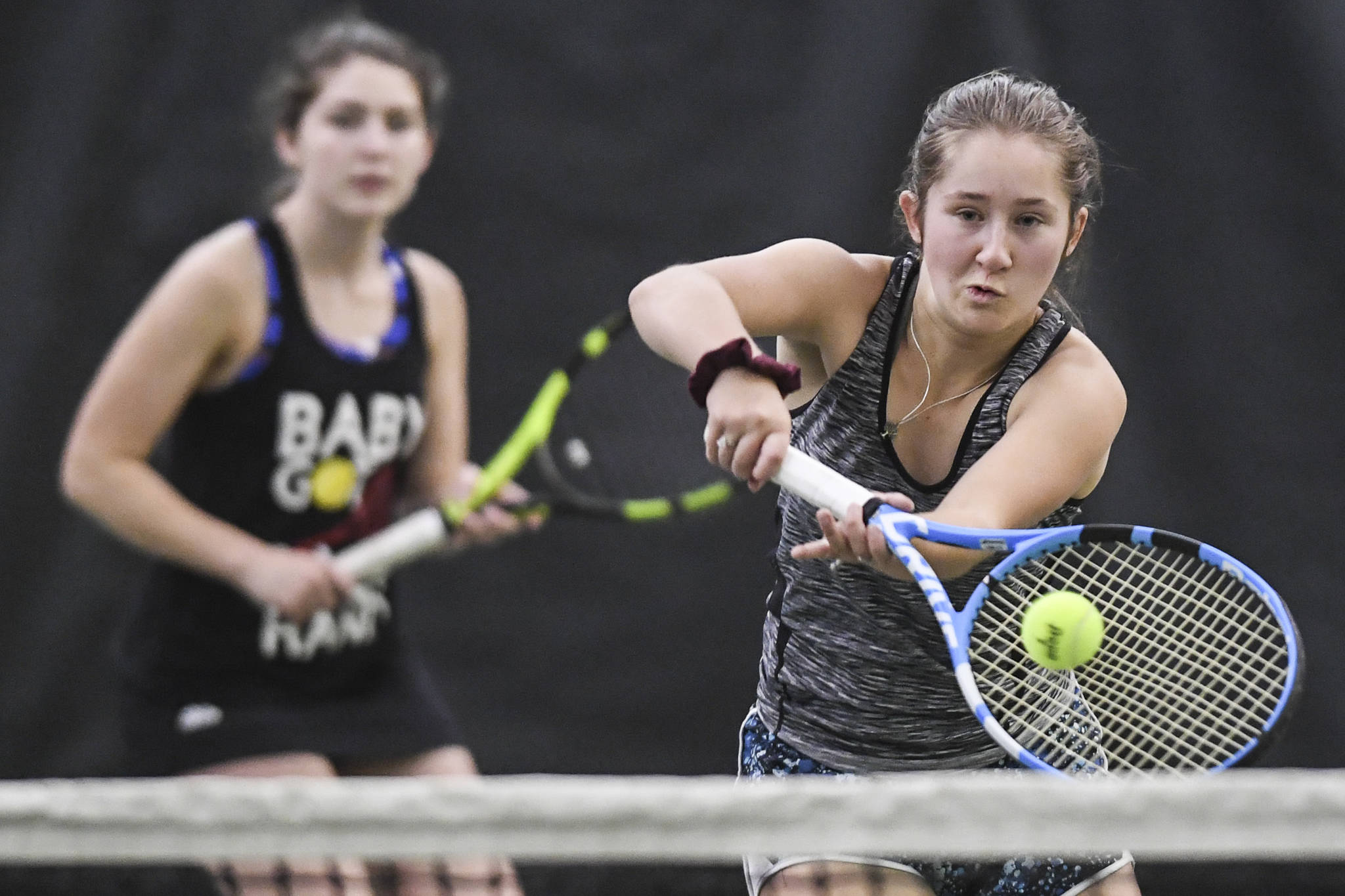 Adelie McMillan, right, hits a volley as she plays in the girls doubles’ final with partner Olivia Moore against Jaymie Collman and Katie Pikul during the Region V Tennis Tournament at The Alaska Club/JRC on Saturday, Sept. 28, 2019. McMillan/Moore won 7-6, 6-4. (Michael Penn | Juneau Empire)