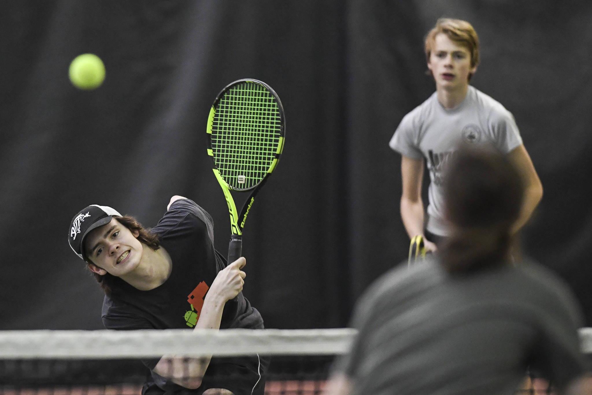 William Smoker, left, returns a volley in a boys doubles’ semifinal with partner Will Rehfeldt against Liam Penn, foreground, and Callan Smith during the Region V Tennis Tournament at The Alaska Club/JRC on Saturday, Sept. 28, 2019. Smoker/Rehfeldt won 7-6, 6-2.(Michael Penn | Juneau Empire)