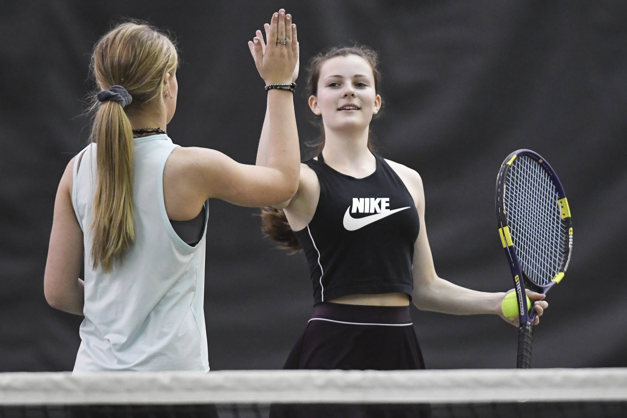 Katie Pikul, right, shares a high five with partner Jaymie Collman in the girls doubles’ final against Adelie McMillan and Olivia Moore during the Region V Tennis Tournament at The Alaska Club/JRC on Saturday, Sept. 28, 2019. McMillan/Moore won 7-6, 6-4. (Michael Penn | Juneau Empire)