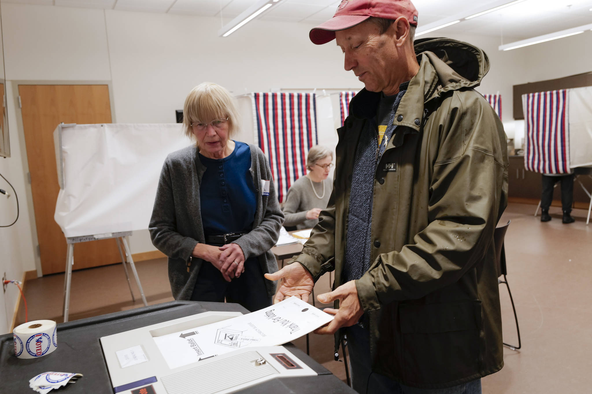 Election official Deborah Behr watches as Doug Woodby enters his ballot into a voting machine at the APK State Library, Archives and Museum Building on Tuesday, Oct. 1, 2019. (Michael Penn | Juneau Empire)