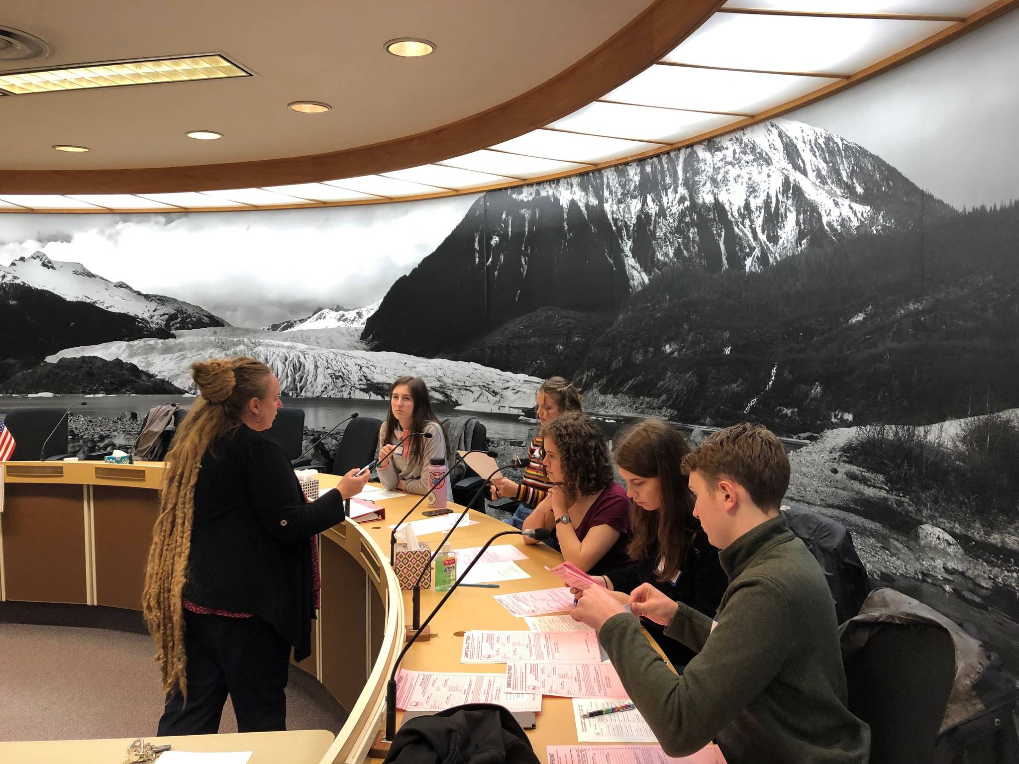 Student volunteers from Thunder Mountain High School receive instructions from Deputy City Clerk Di Cathcart. (Peter Segall | Juneau Empire)