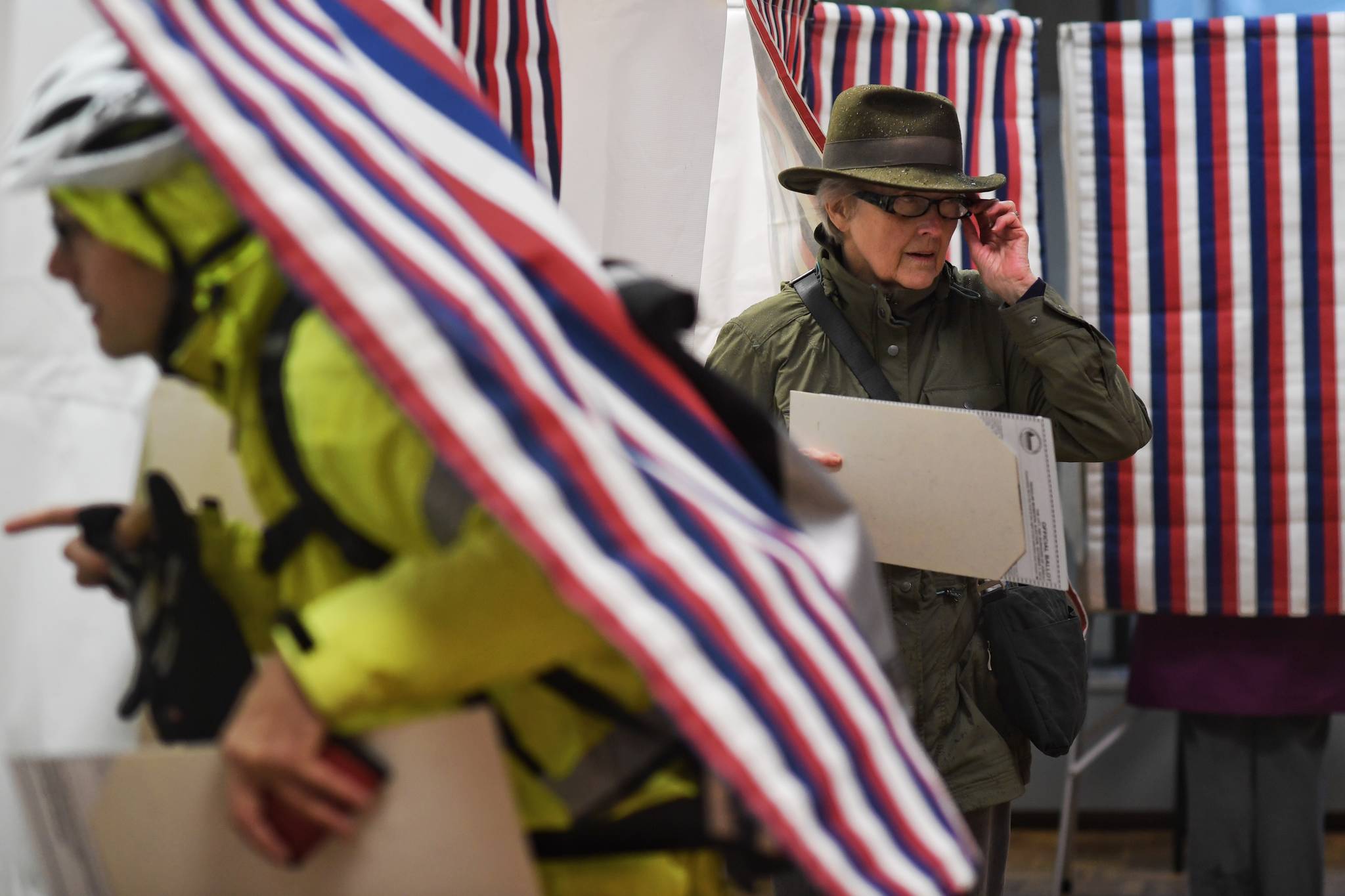 Ben Williams, left, heads into the voting booth as Suzanne Williams leaves after voting at the Douglas Public Library on Tuesday, Oct. 1, 2019. (Michael Penn | Juneau Empire)