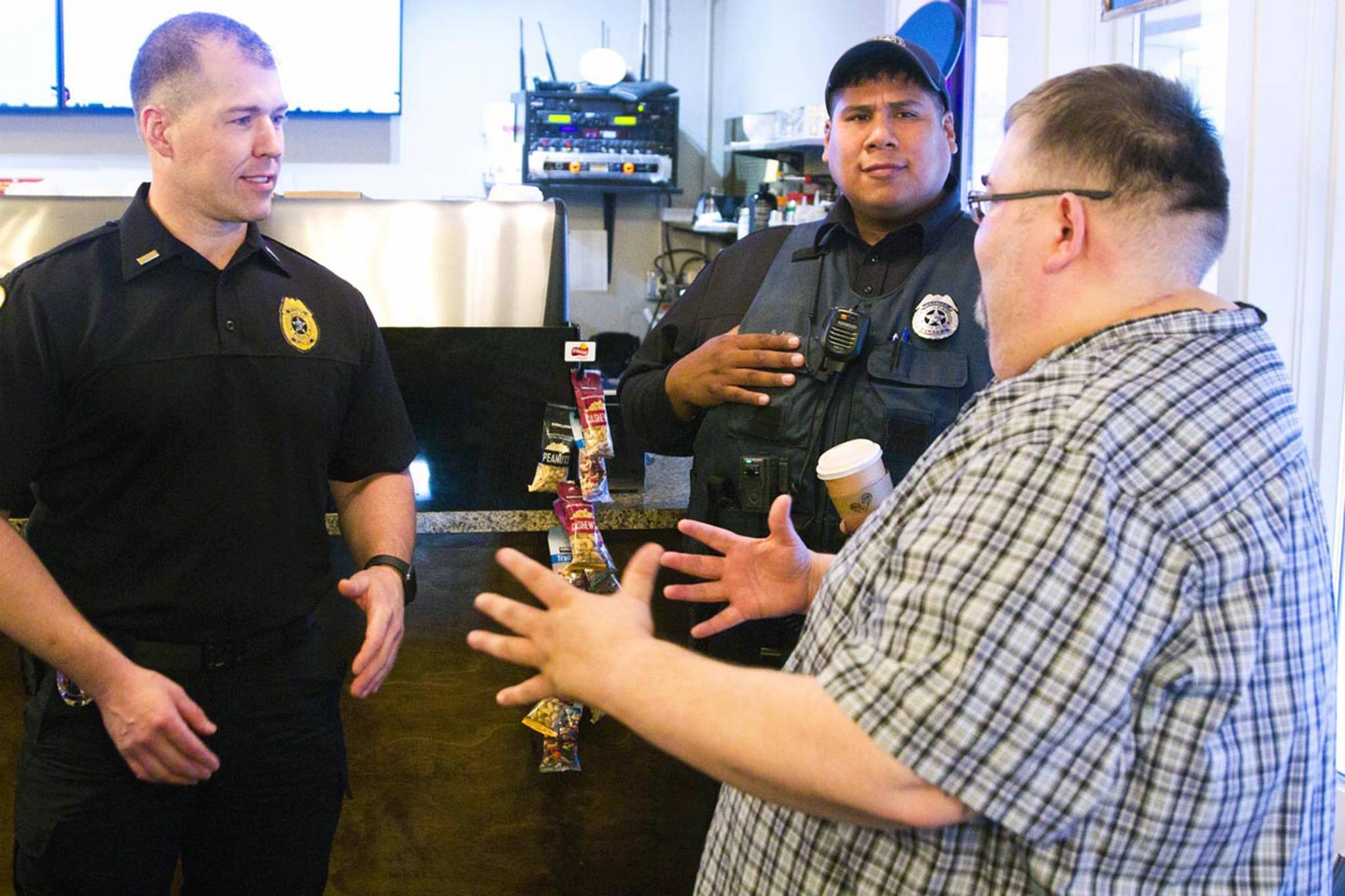 Lt. Krag Campbell with the Juneau Police Department talks with Richard Peterson, president of the Central Council of Tlingit and Haida Indian Tribes of Alaska, during Coffee with a Cop at Sacred Grounds on Oct. 2, 2019. (Michael S. Lockett | Juneau Empire)