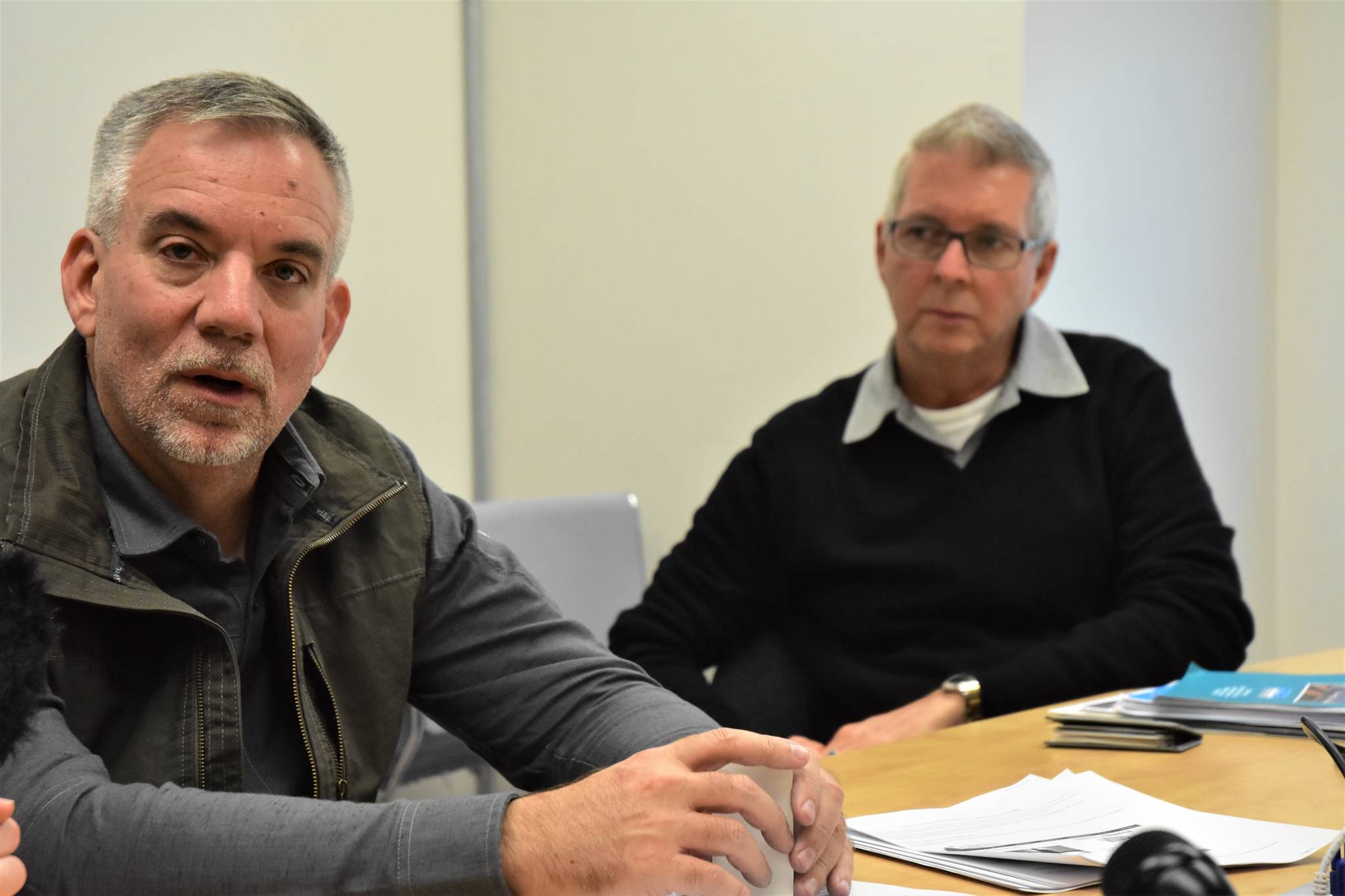 Howard Sherman, left, executive vice president of onboard revenue and destination services for Norwegian Cruise Lines and Steve Moeller, right, senior vice president of commercial development at Norwegian, meet with reporters at Juneau City Hall on Oct. 2, 2019. (Peter Segall | Juneau Empire)