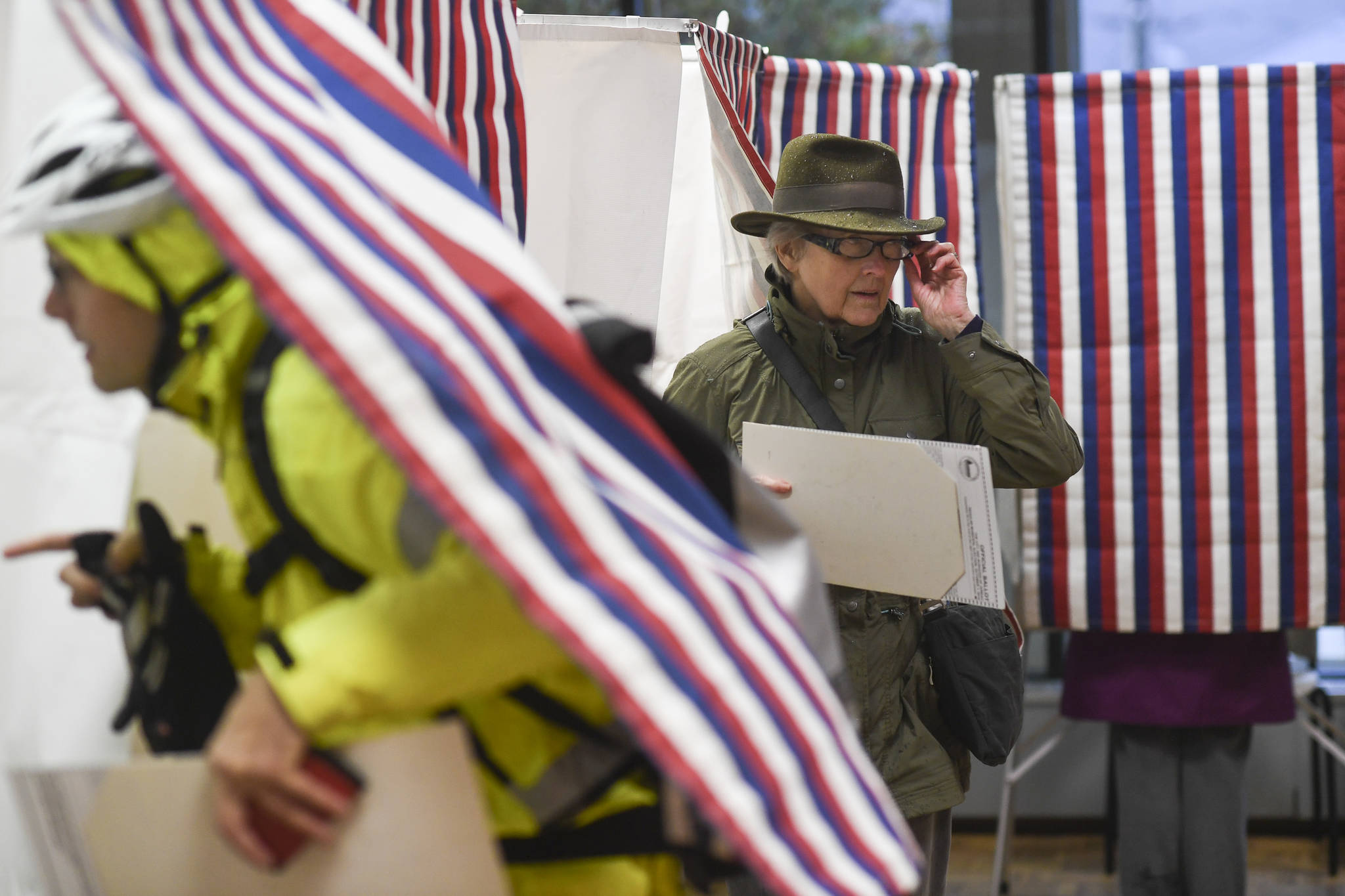 Ben Williams enters a voting booth as Suzanne Williams exits after voting at the Douglas Public Library on Tuesday, Oct. 1, 2019. (Michael Penn | Juneau Empire)