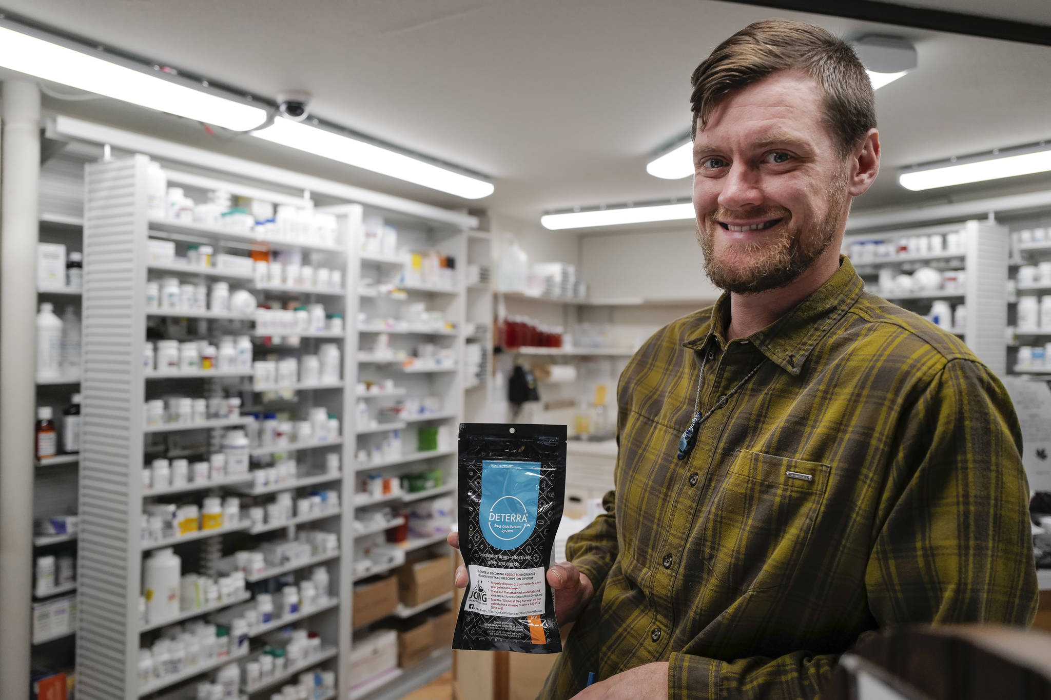Adam Nelson, a pharmacist at Juneau Drug, displays a drug deactivation bag on Tuesday, Oct. 1, 2019, he gives out with opioid prescriptions. People can use the bag to safely dispose of unused drugs. (Michael Penn | Juneau Empire)