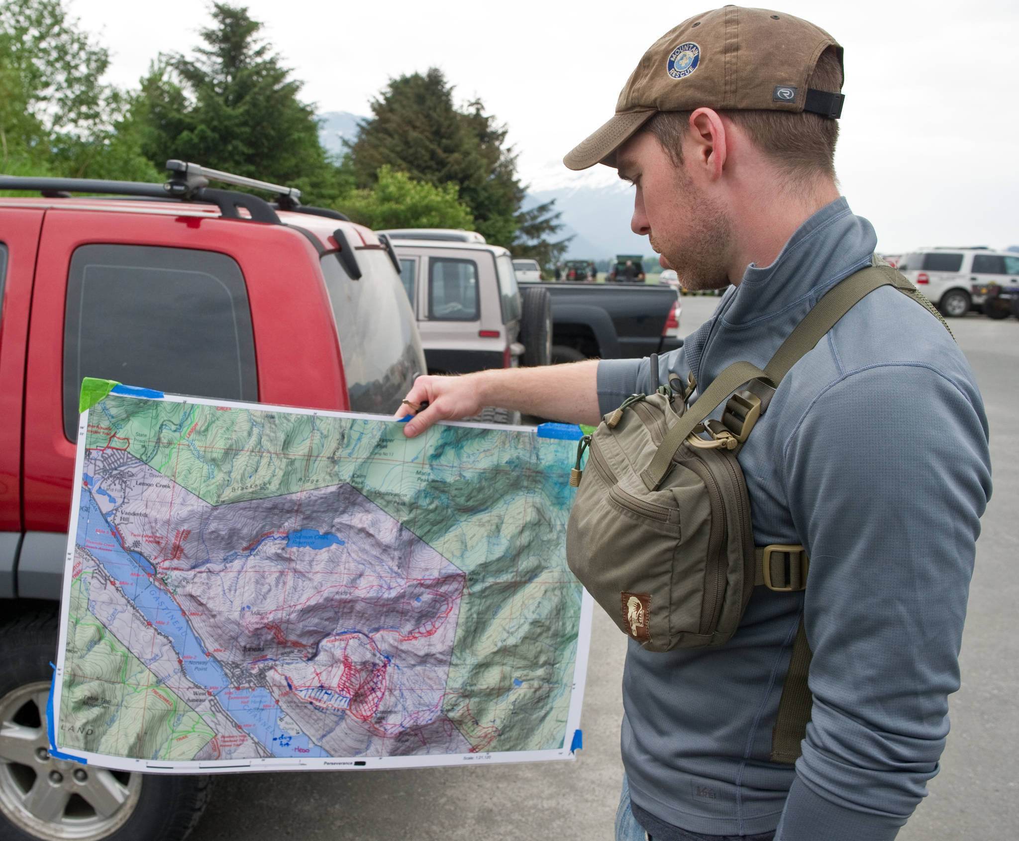 Juneau Mountain Rescue member James Dooley holds a map of the search area after a morning briefing at TEMSCO. Searchers are looking for 48-year-old Juneau resident Sharon Buis, who was missing in the Mount Roberts in 2014. (Michael Penn | Juneau Empire File)