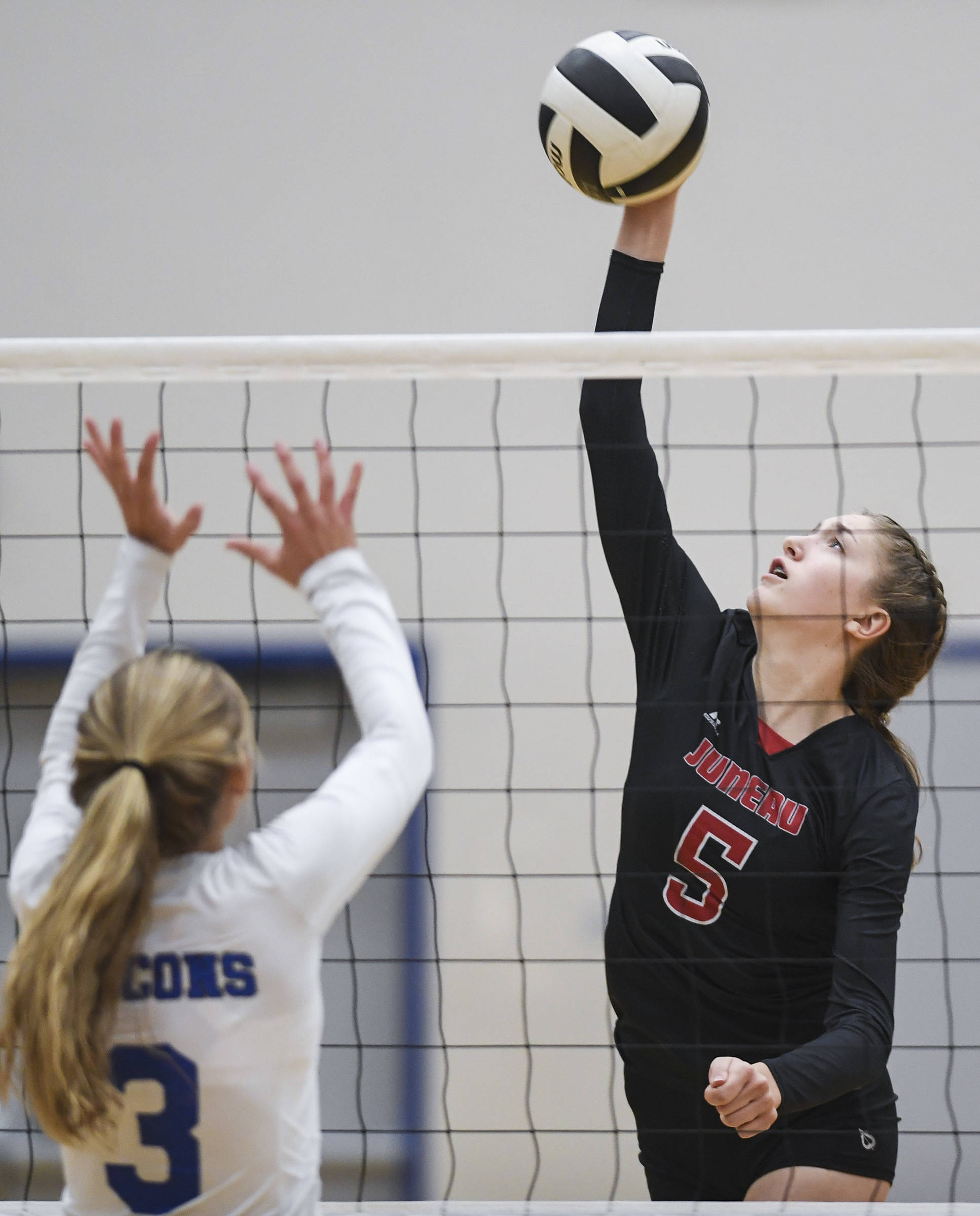 Juneau-Douglas’ Brooke Sanford, right, spikes the ball against Thunder Mountain’s Lily Smith at Thunder Mountain High School on Friday, Oct. 4, 2019. (Michael Penn | Juneau Empire)