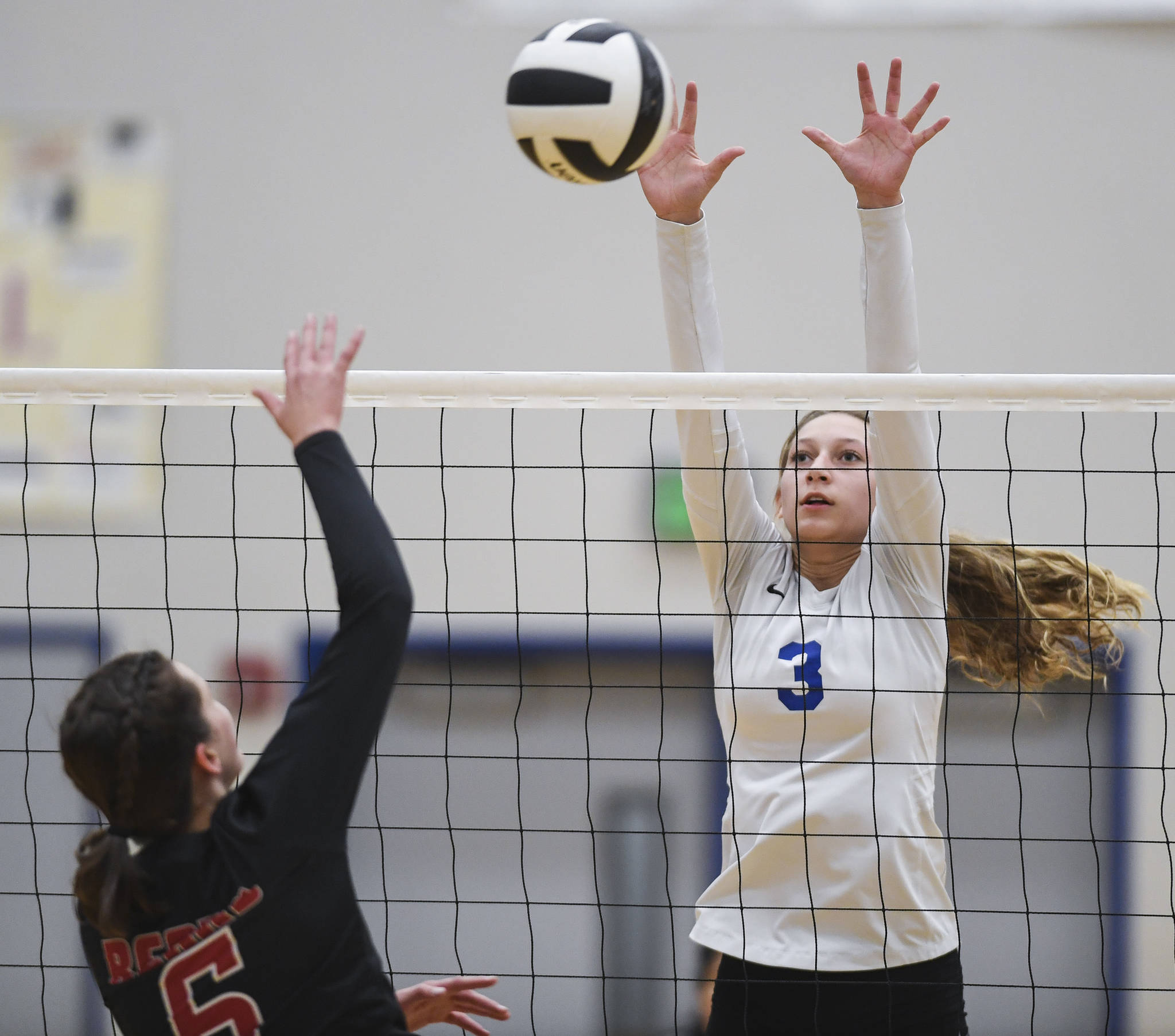 Thunder Mountain’s Lily Smith, right, attempts a block against Juneau-Douglas’ Addie Prussing at Thunder Mountain High School on Friday, Oct. 4, 2019. (Michael Penn | Juneau Empire)