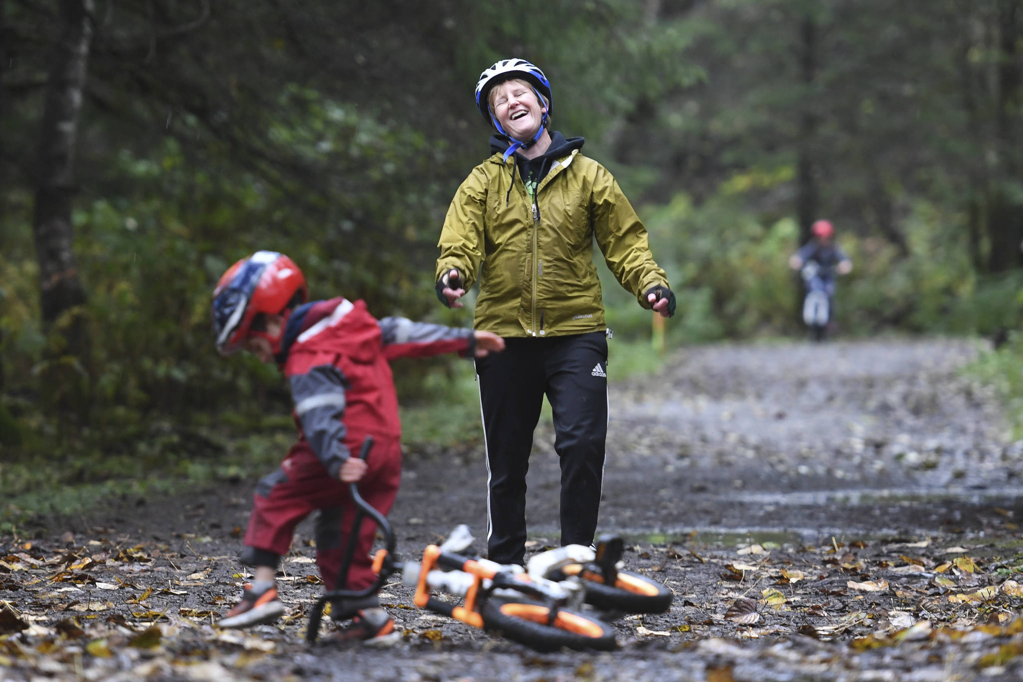 Joanna Quigg laughs as Joshua, 4, falls off his bike during the Douglas Dirt Derby Youth Bike Race at Savikko Park and the Treadwell Historic Trail on Saturday, Oct. 5, 2019. The event was organized by the Juneau Freewheelers Bicycle Club. (Michael Penn | Juneau Empire)