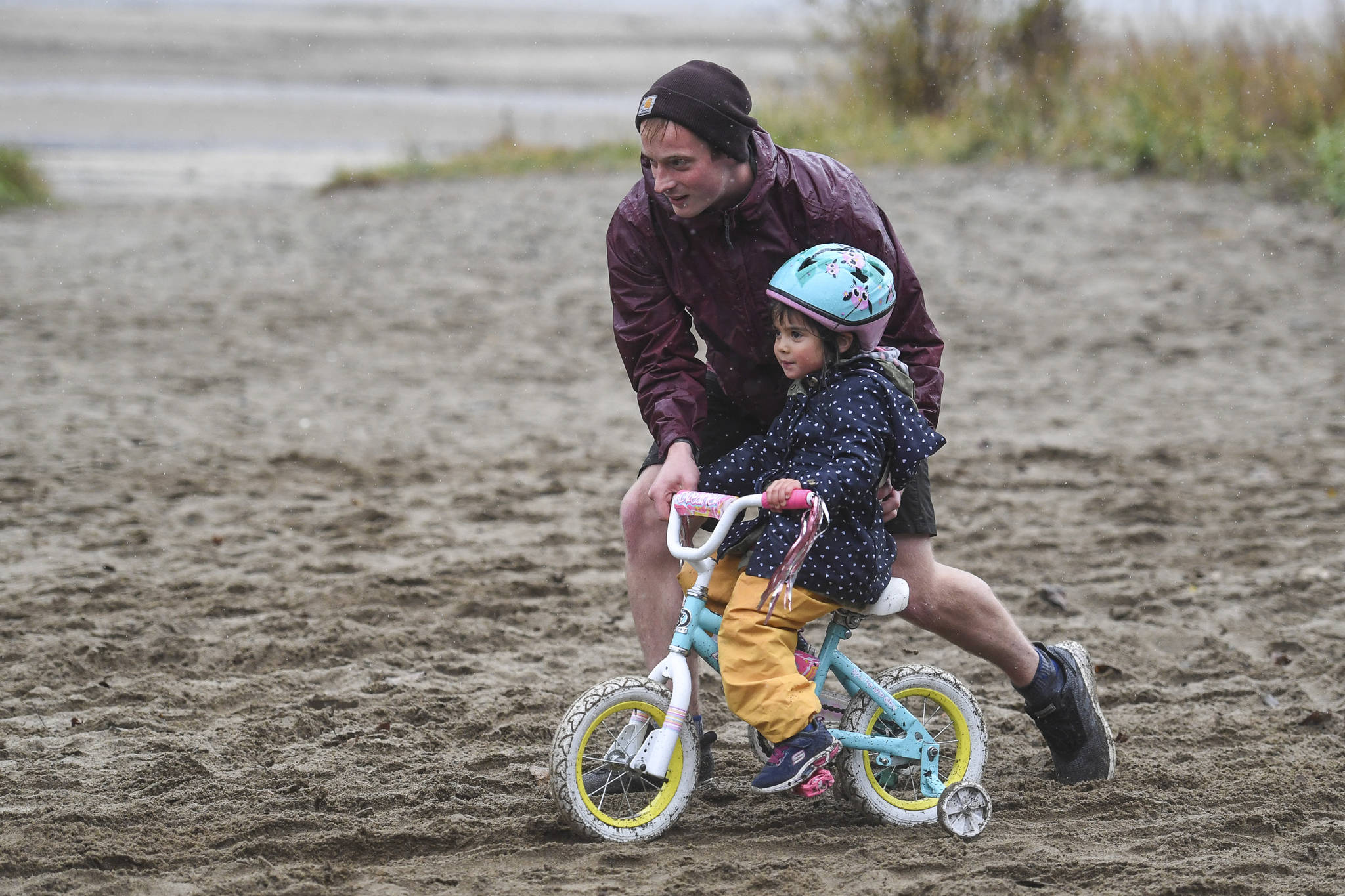 Dylan Kruger helps his daughter, Amelia, 4, at the finish of the Douglas Dirt Derby Youth Bike Race for 5 to 7-year-olds at Savikko Park and the Treadwell Historic Trail on Saturday, Oct. 5, 2019. The event was organized by the Juneau Freewheelers Bicycle Club. (Michael Penn | Juneau Empire)