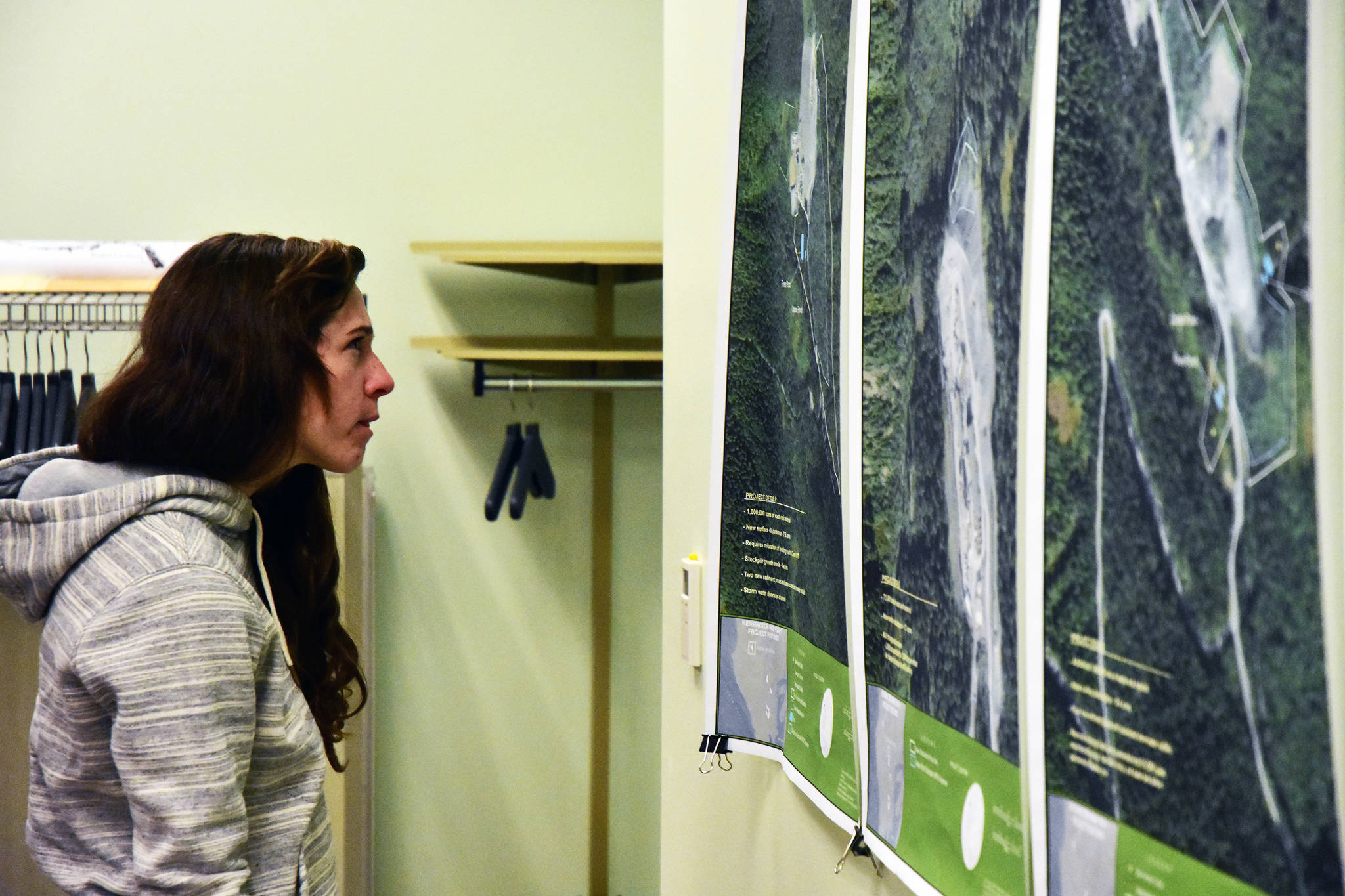A member of the public examines maps of the proposed expansion to Coeur Alaska’s Kensington Mine facilities at the Juneau Ranger District Station on Oct. 8, 2019 (Peter Segall | Juneau Empire)