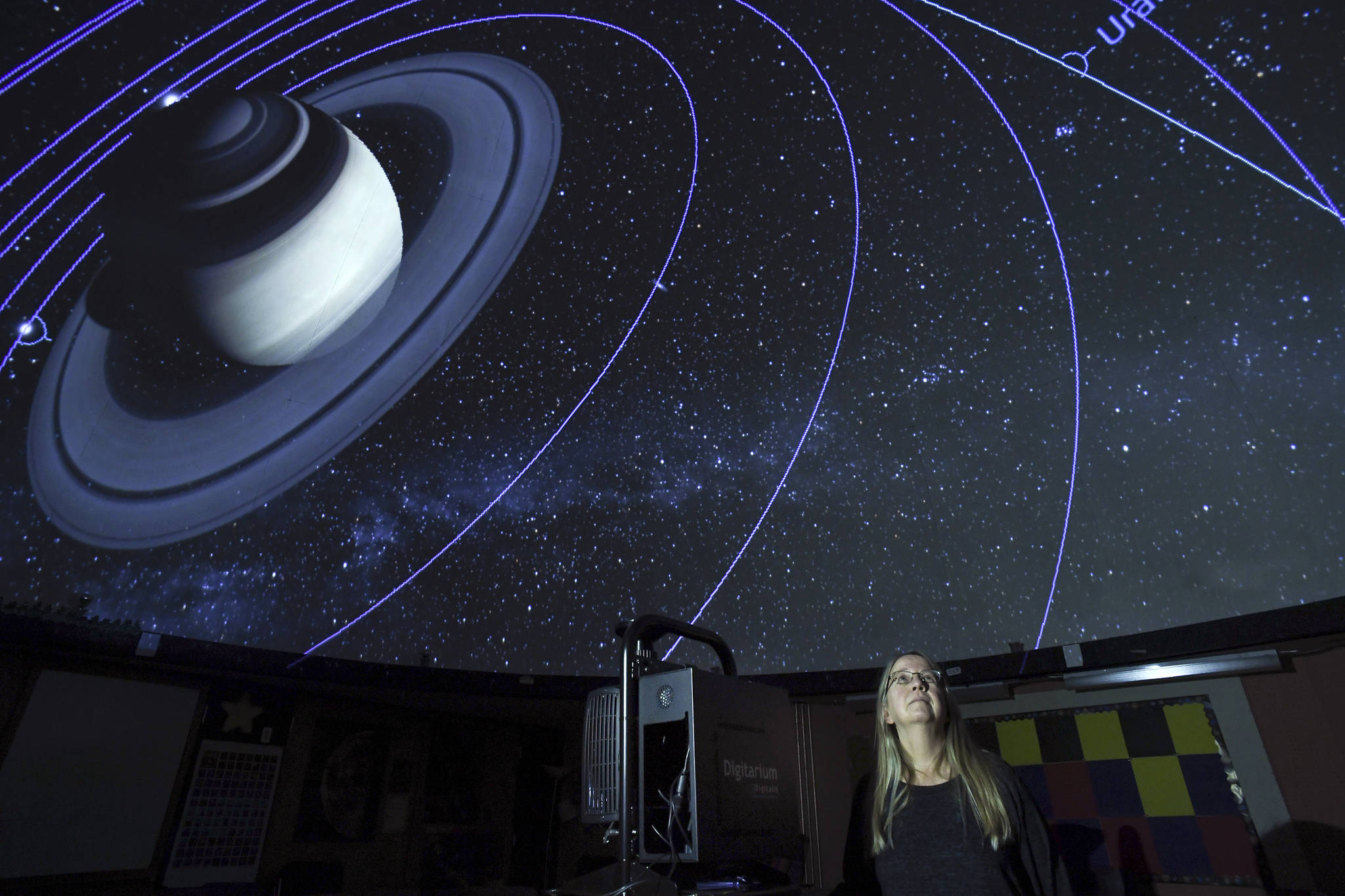Rosemary Walling, a volunteer and board member of Friends of the Marie Drake Planetarium, views Saturn and its moons’ orbits as projected by a visiting digital projector from Seattle’s Museum of Flight on Thursday, Oct. 10, 2019. The planetarium is currently raising money to replace its aging mechanical projector with a digital one. (Michael Penn | Juneau Empire)