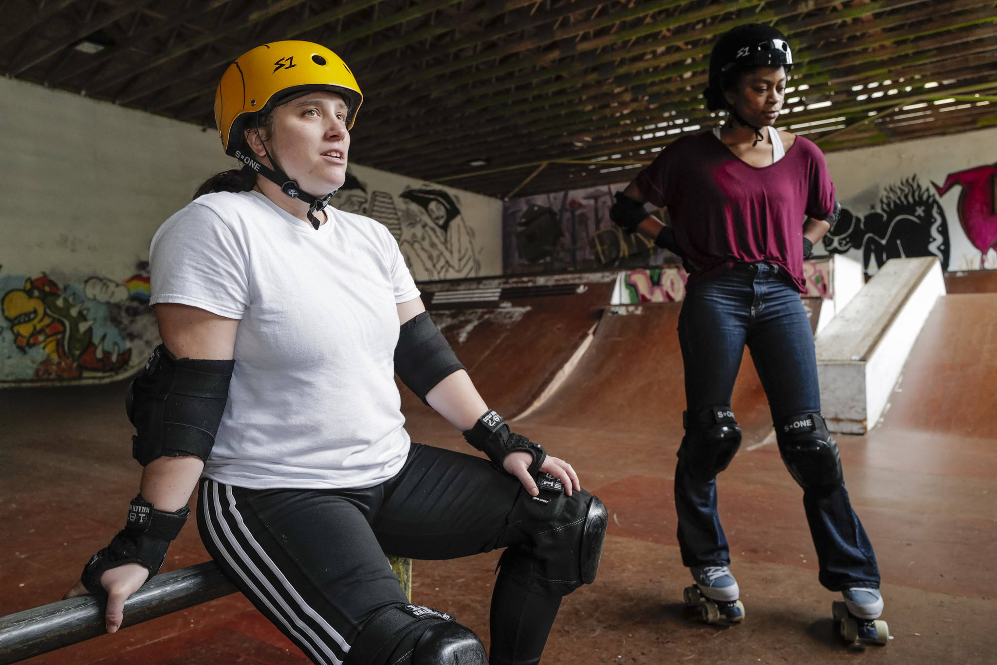 Shabadrang Khalsa, left, and Jennifer Gross, who skate with the Juneau Rollergirls, talk about what rollerskating means to them during a break getting their daily skate in at the Pipeline Skate Park on Friday, Oct. 11, 2019. The two are skating every day as part of a challenge to every day for a year. (Michael Penn | Juneau Empire)