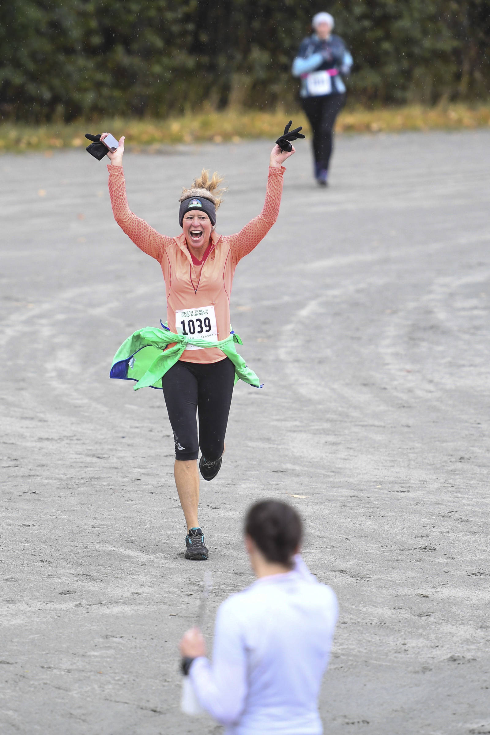 Colleen Jones celebrates her finish at the annual community mental health run, the Extra Tough 5K & 1 Mile Run, on Saturday, Oct. 12, 2019, at Riverbend Elementary School. The run is sponsored by National Alliance on Mental Illness (NAMI) Juneau. (Michael Penn | Juneau Empire)