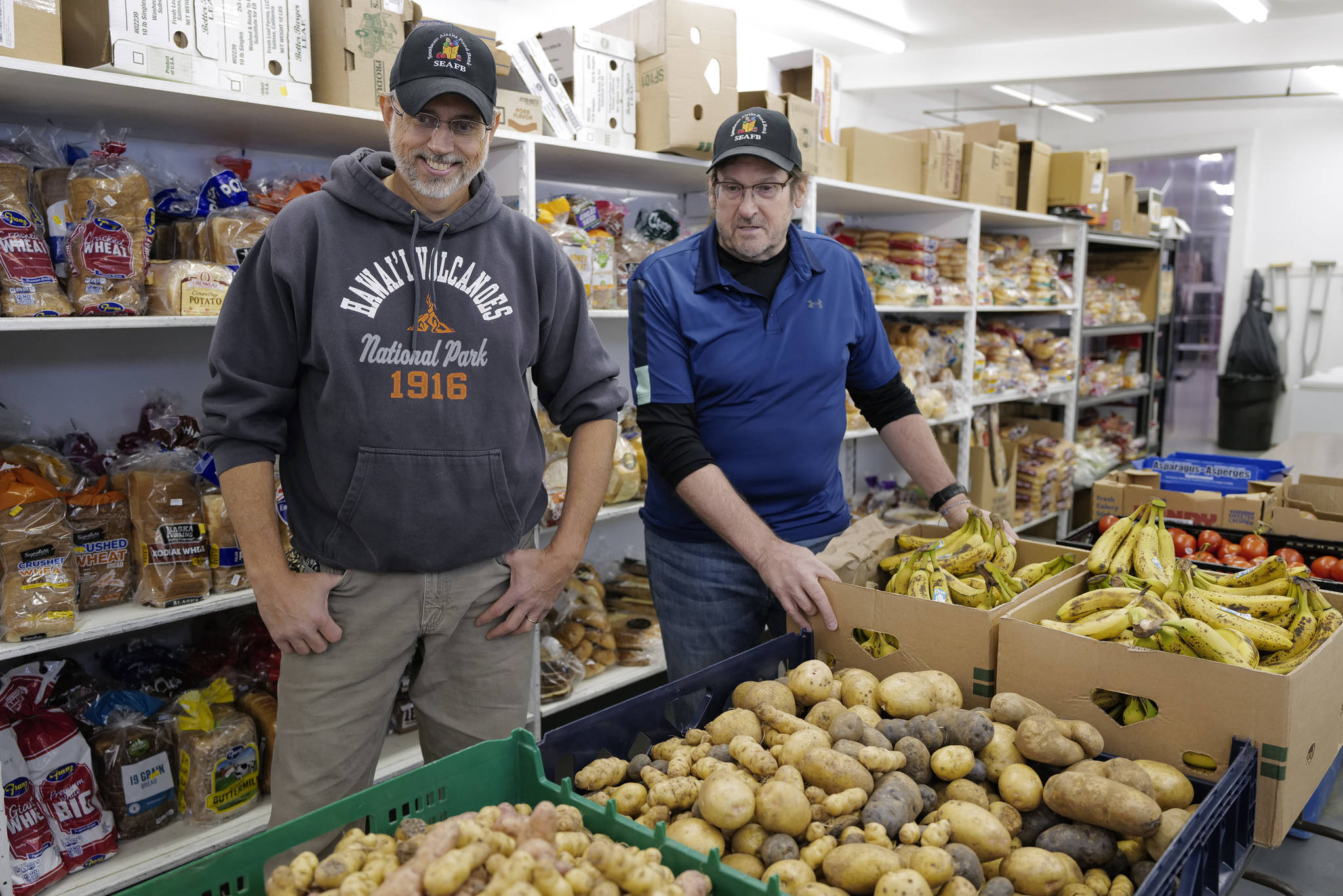 Southeast Alaska Food Bank manager Chris Schapp, left, looks over freshly-dug potatoes from the Juneau Community Garden with president Dave Lefebvre at the food bank on Crazy Horse Drive on Tuesday, Oct. 15, 2019. (Michael Penn | Juneau Empire)