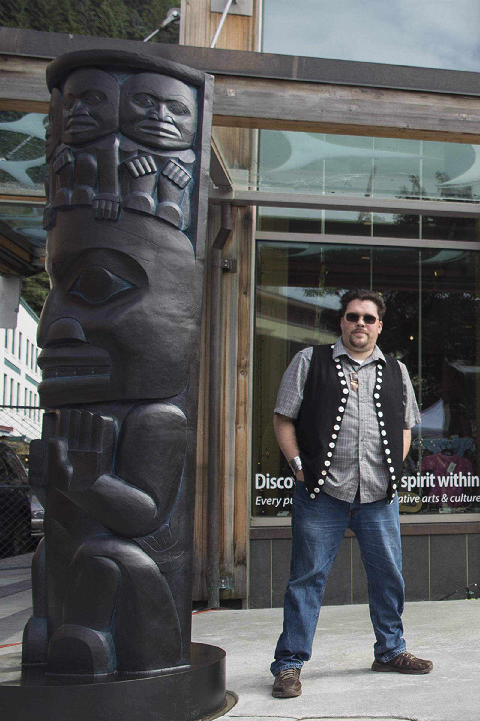 Tsimshian artist David R. Boxley stands by their bronze house posts during an unveiling ceremony in front of the Walter Soboleff Center by Sealaska Heritage Institute on Sunday, Aug. 26, 2018. (Michael Penn | Juneau Empire File)