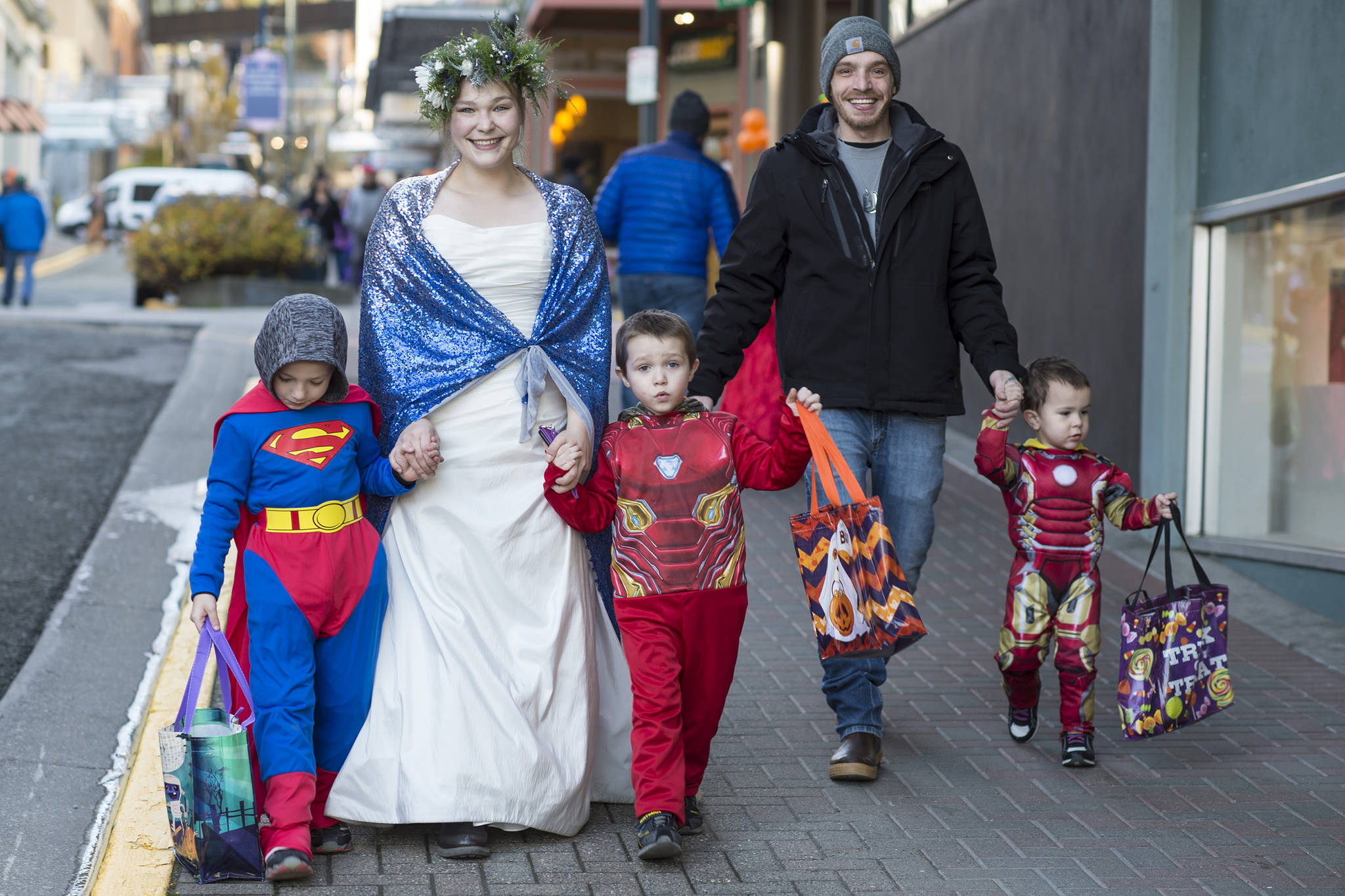 Michelle Ward and Anthony Davidson walk their children, Kyesin, 6, left, CJ, 5, center, and Callen, 2, down Seward Street as they visit downtown merchants for Halloween 2018. (Michael Penn | Juneau Empire File)