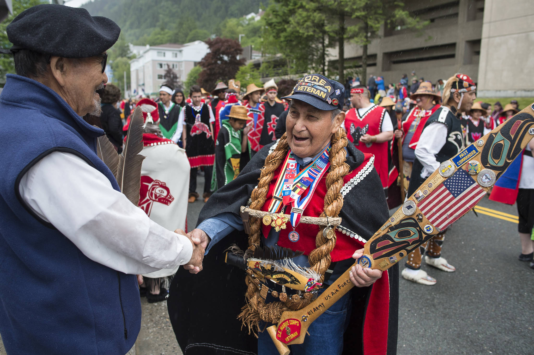 Marine veteran Marvin Kadake, right, of the Keex’ Kwaan Dancers (People of Kake) shakes hands with Ed Kunz during the Grand Entrance for Celebration 2018 along Willoughby Avenue on Wednesday, June 6, 2018. (Michael Penn | Juneau Empire)