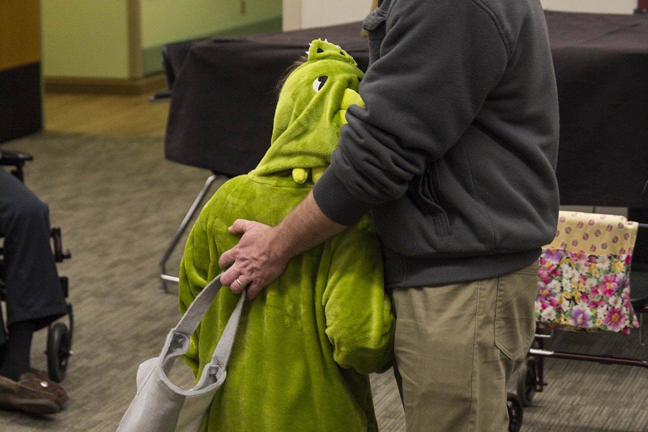 A parent hugs his child as members of the Parents as Teachers program and a number of children visited the Juneau Pioneer Home to have an early Halloween with the residents on Tuesday, Oct. 22, 2019. (Michael S. Lockett | Juneau Empire)