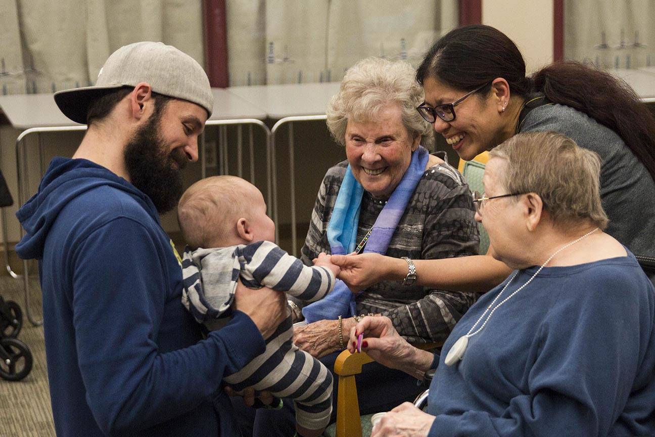 Residents of the Juneau Pioneer Home play with a baby as members of the Parents as Teachers program and a number of children visited to have an early Halloween on Tuesday, Oct. 22, 2019. (Michael S. Lockett | Juneau Empire)