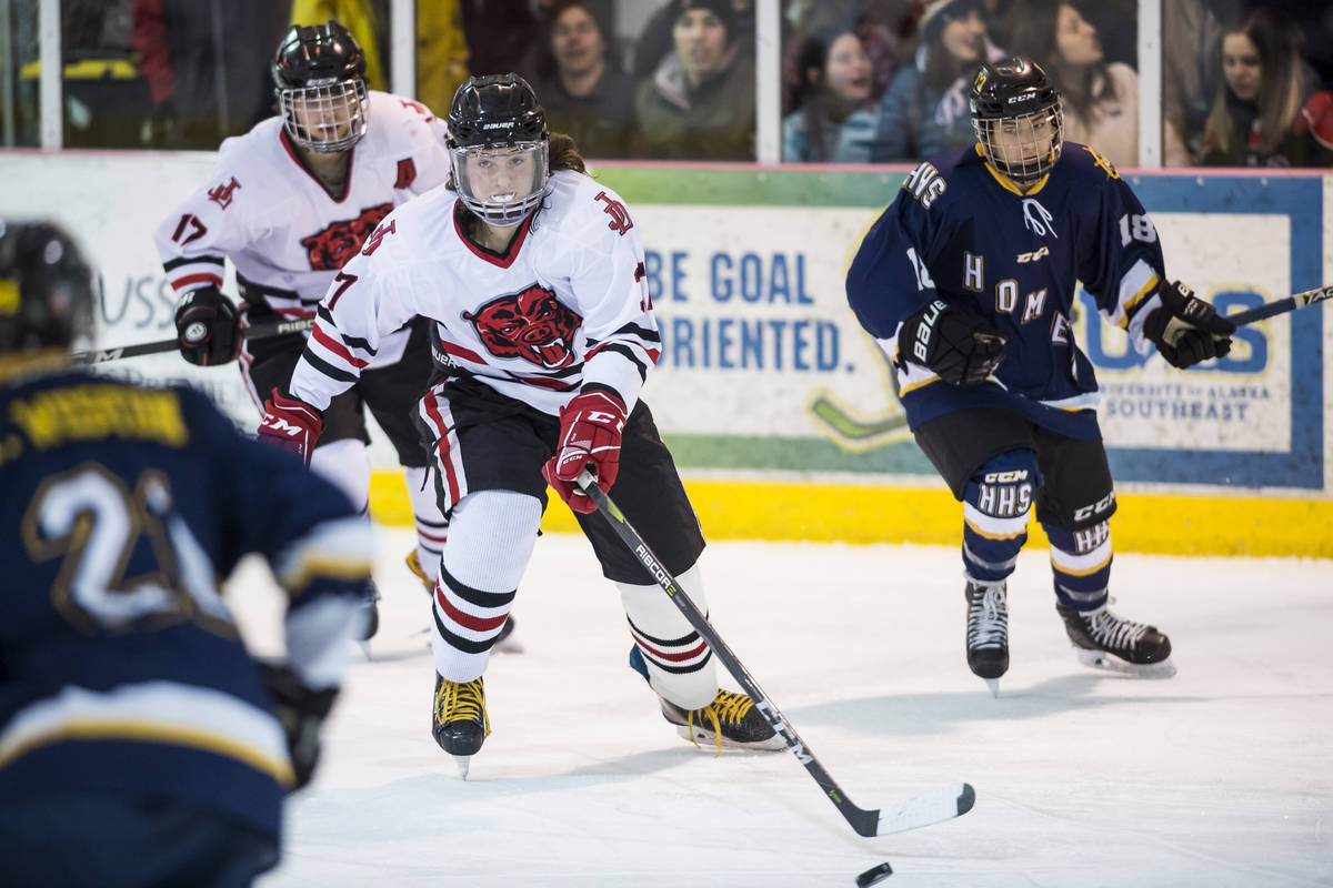 Juneau-Douglas’ Chance Turinsky, center, moves the puck against Homer at Treadwell Arena on Friday, Jan. 18, 2019. JDHS won 4-3 in overtime. (Michael Penn | Juneau Empire File)
