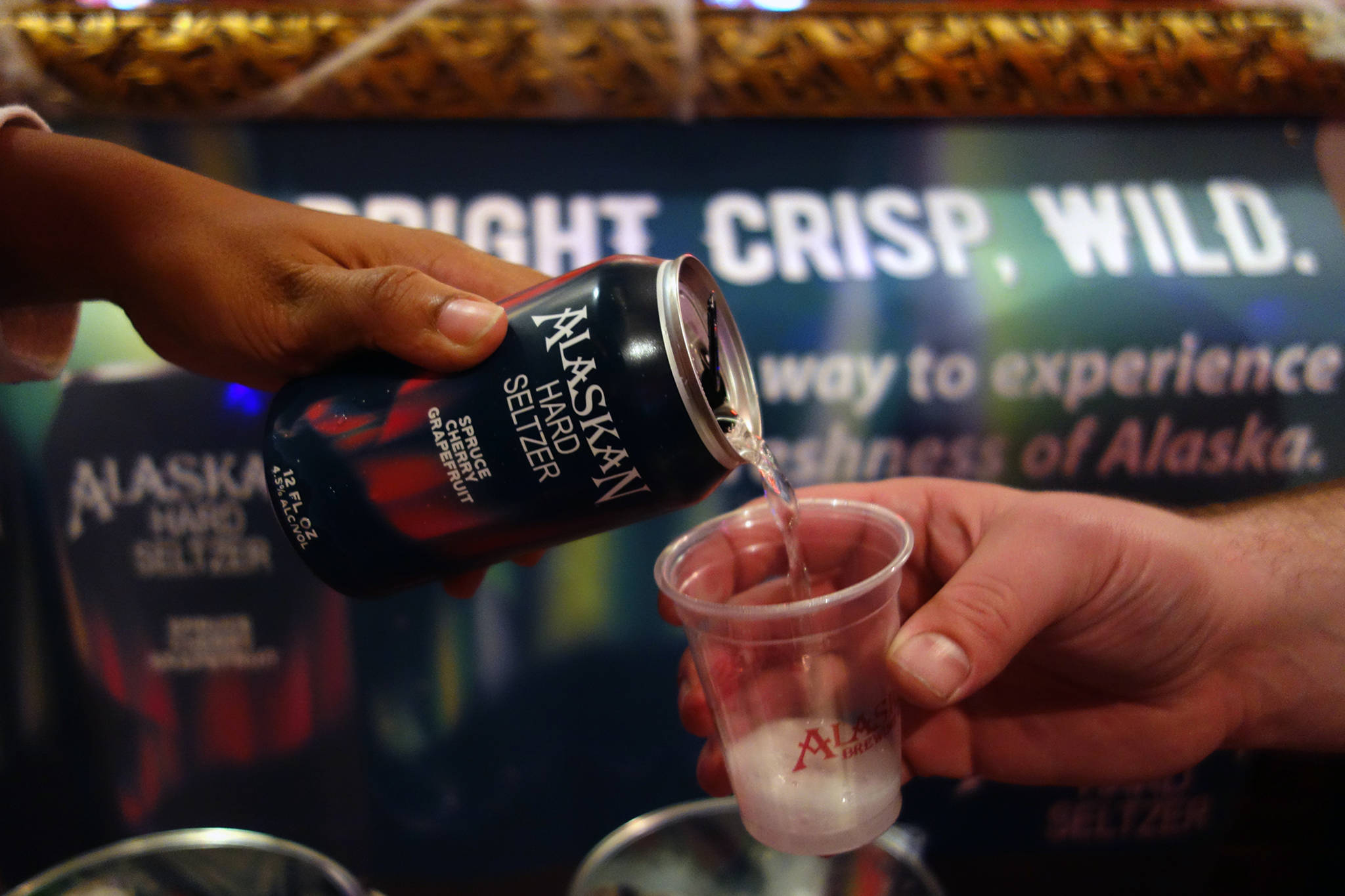 Alaskan Brewing Co. employees pour a sample of a new spruce cherry grapefruit hard seltzer at the Imperial Saloon, Friday, Oct. 25, 2019. (Ben Hohenstatt | Juneau Empire)