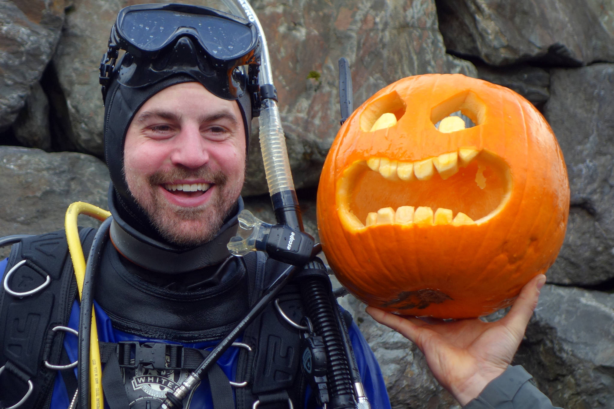 Darren Jaeckel smiles near a jack-o’-lantern he carved underwater at the Sixth Annual Spooktacular Dive and Underwater Pumpkin Carving event Saturday, Oct. 26, 2019. (Ben Hohenstatt | Juneau Empire)