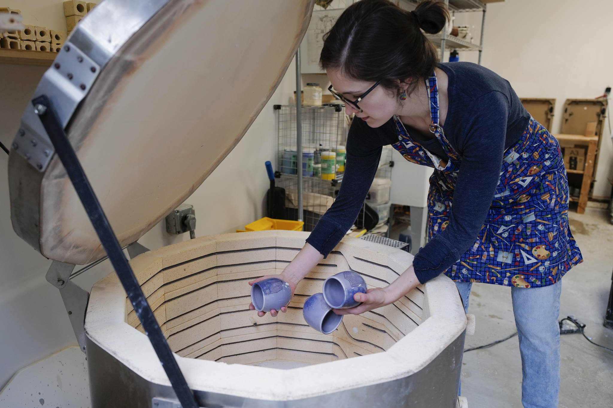 Mercedes Muñoz takes ceramic cups out of her home studio kiln on Monday, Oct. 28, 2019, as she prepares for a First Friday show at Coppa. (Michael Penn | Juneau Empire)