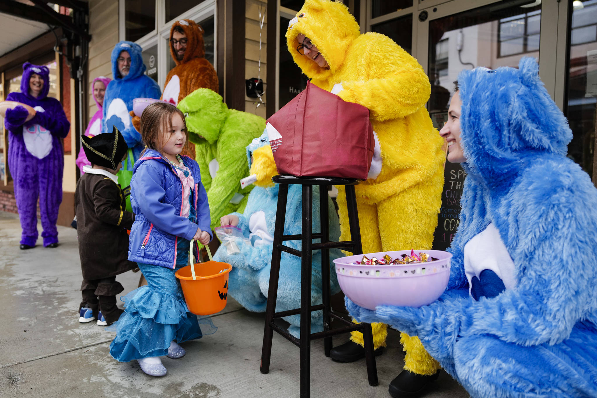 Members of Front Street Clinic greet Harlyn Noe, 3, during the Trick or Treat Downtown event on Thursday, Oct. 31, 2019. More than 70 business put out orange balloons to participate in the event aimed at young children. (Michael Penn | Juneau Empire)