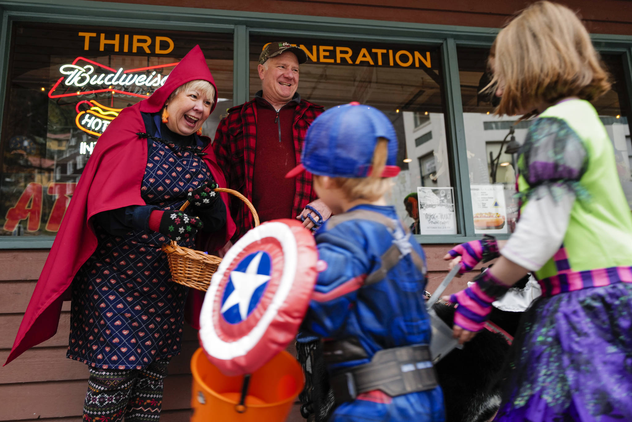 Jewels and Joe Butler greet children in front of the Triangle Bar during the Trick or Treat Downtown event on Thursday, Oct. 31, 2019. More than 70 business put out orange balloons to participate in the event aimed at young children. (Michael Penn | Juneau Empire)
