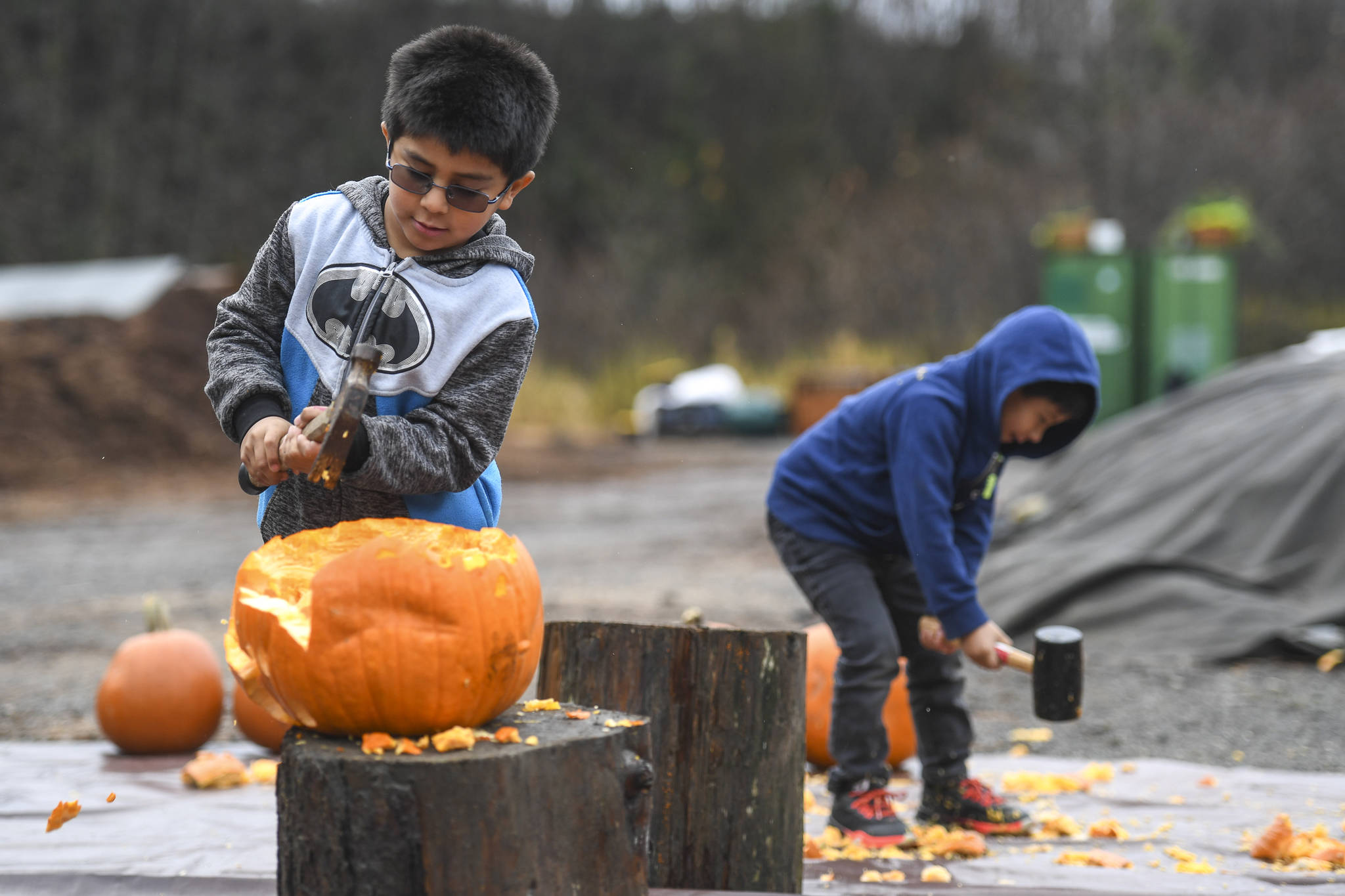 Emilio Delgado, 6, left, and his brother, Jolvanni, 5, smash pumpkins at Juneau Composts! on Sunday, Nov. 3, 2019. Juneau Composts! owner Lisa Daugherty put on the event as a fun way of keeping the holiday pumkins out of the landfill. (Michael Penn | Juneau Empire)