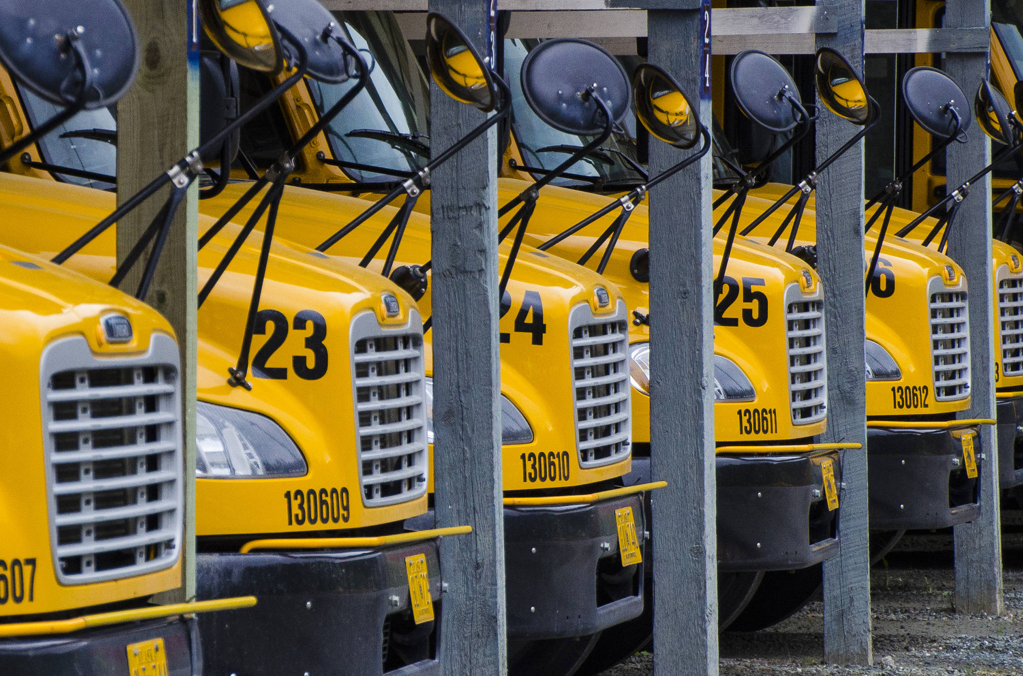 School buses sit idle at the First Student lot on Mendenhall Loop Road in this May 2014 photo. (Michael Penn \ Juneau Empire File)