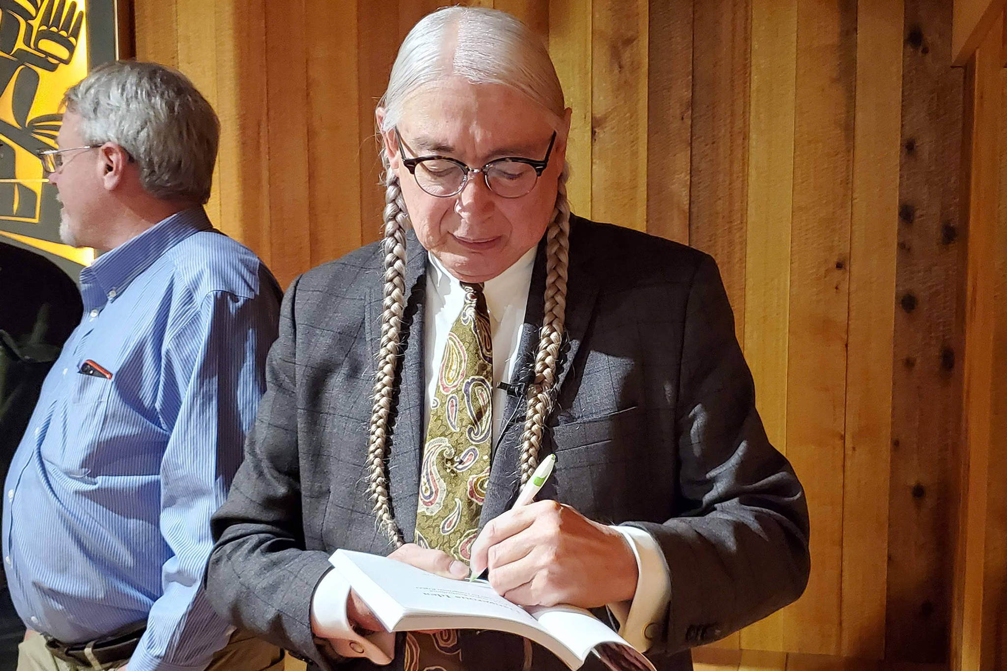 Walter Echo-Hawk, a speaker, attorney and author, signs a book after discussing the Tee-Hit-Ton v. United States case during a lecture at Sealaska Heritage Institute’s Walter Soboleff building Thursday, Nov. 7, 2019. (Ben Hohenstatt | Juneau Empire)