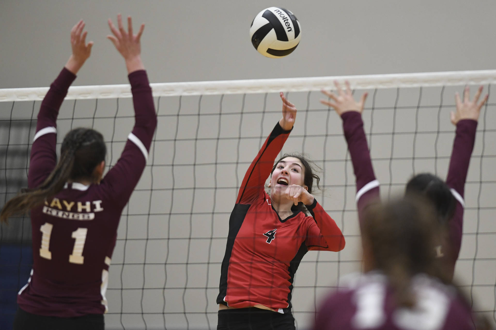 Juneau-Douglas’ Jenae Pusich spikes the ball against Ketchikan’s Lindsey Byron, left, and Maddy Purcell during the Region V Volleyball Tournament at Thunder Mountain High School on Thursday, Nov. 7, 2019. JDHS won 25-8, 25-14, 14-25, 25-15. (Michael Penn | Juneau Empire)