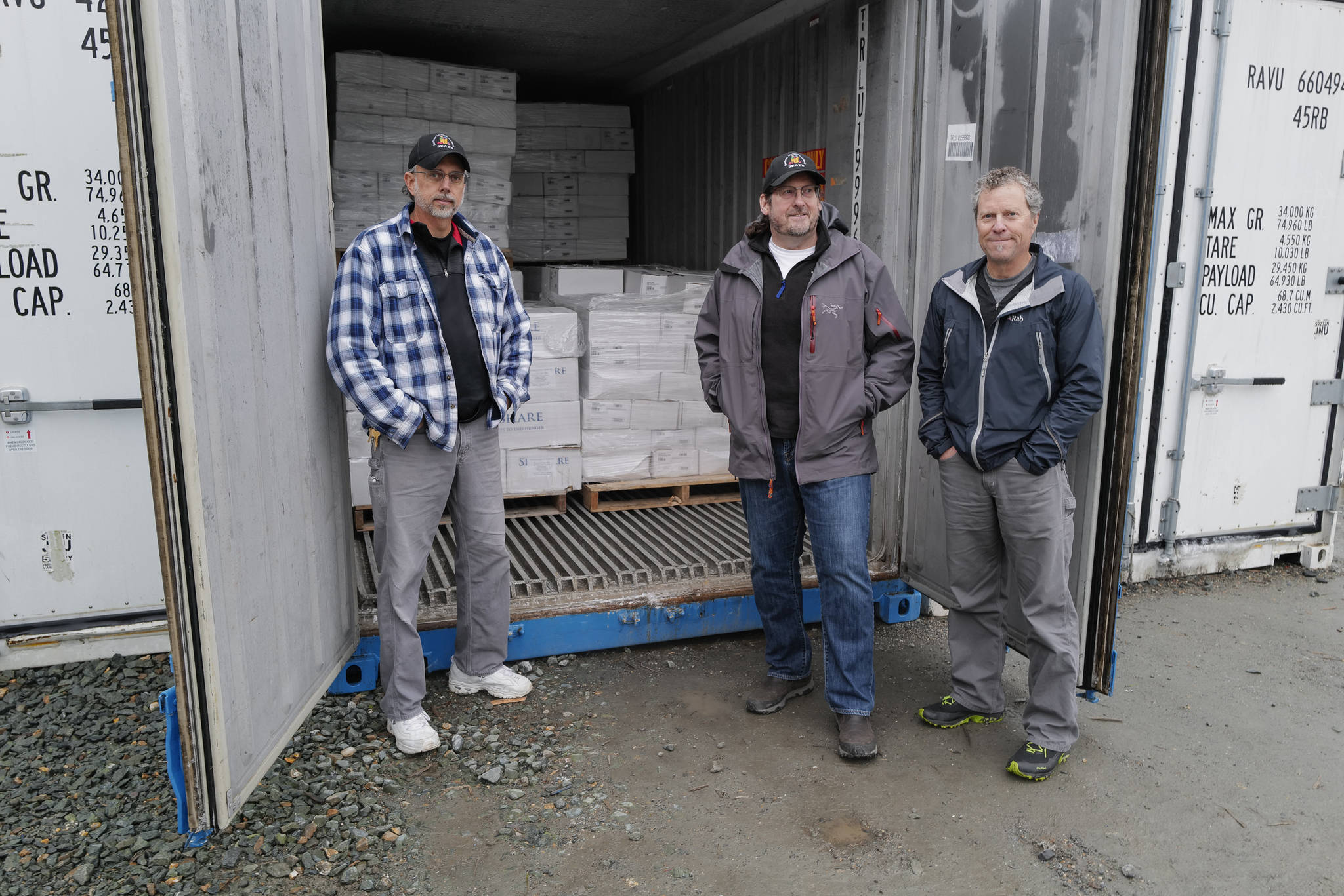 Chris Shapp, left, and Dave Lefebvre, center, of the Southeast Alaska Food Bank, stand with Jim Harmon, executive director of SeaShare, on Thursday, Nov. 7, 2019. Seashare donated a 40-foot freezer van and 20,000 pounds of seafood to the foodbank. SeaShare is a nonprofit founded in 1994 to help the seafood industry donate to hunger-relief efforts. The effort has prevented 5 million pounds of bycatch over 25 years from being dumped back into the ocean. (Michael Penn | Juneau Empire)