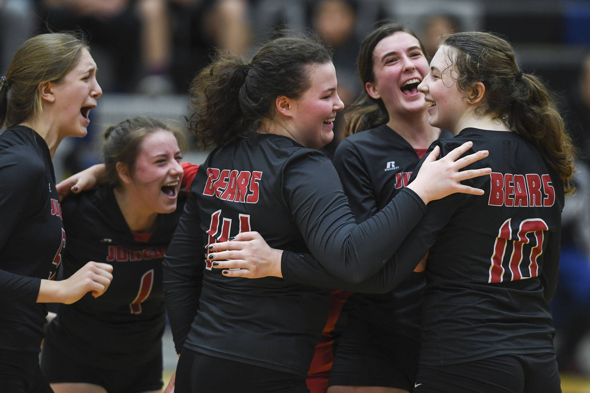Juneau-Douglas’ Brooke Sanford, left, Kiana Potter, Gabi Griggs, Addie Prussing and Merry Newman, right, celebrate their win over Thunder Mountain during the Region V Volleyball Tournament at Thunder Mountain High School on Friday, Nov. 8, 2019. JDHS won 25-22, 26-24, 25-20. (Michael Penn | Juneau Empire)