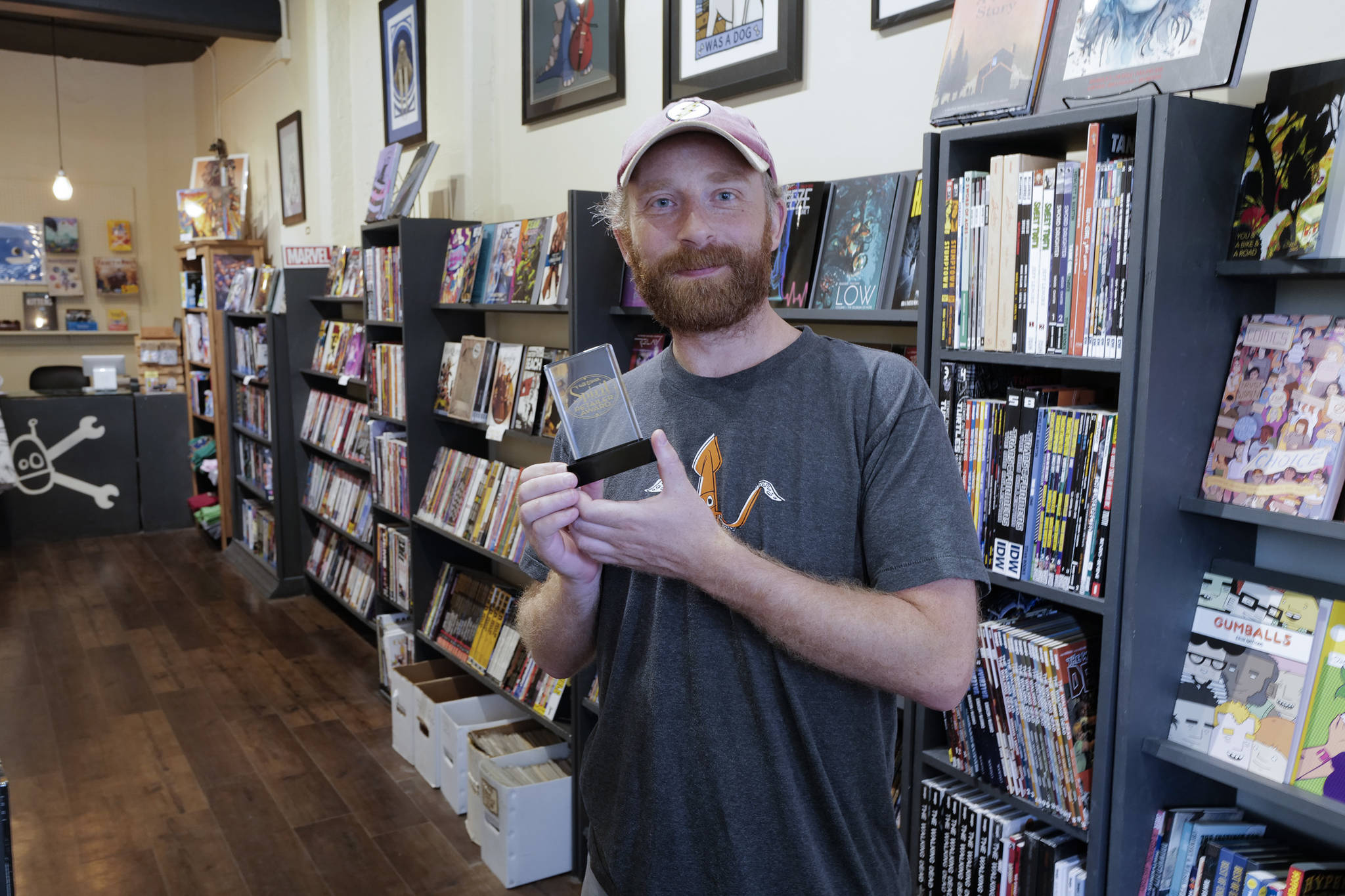 Pat Race displays the Will Eiser Spirit of Comics Retailer Award at his Alaska Robotic Gallery during First Friday on Friday in August. Race will be a featured artist for the upcoming Tidal Echoes art and literary journal. (Michael Penn | Juneau Empire File)