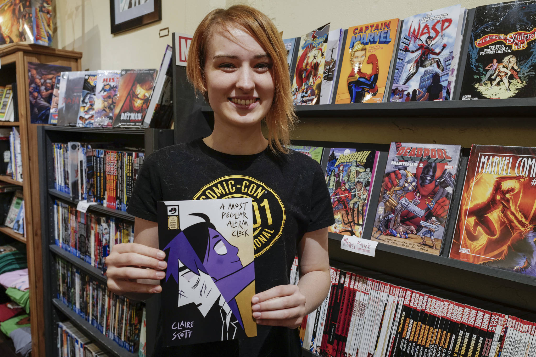 Claire Scott, 16, a junior at Juneau-Douglas High School: Yadaa.at Kalé, shows off her second published comic book, A Most Peculiar Alarm Clock, at Alaska Robotics Gallery on Tuesday, Nov. 12, 2019. Scott’s first book, Meow Cats United, was published last year. (Michael Penn | Juneau Empire)