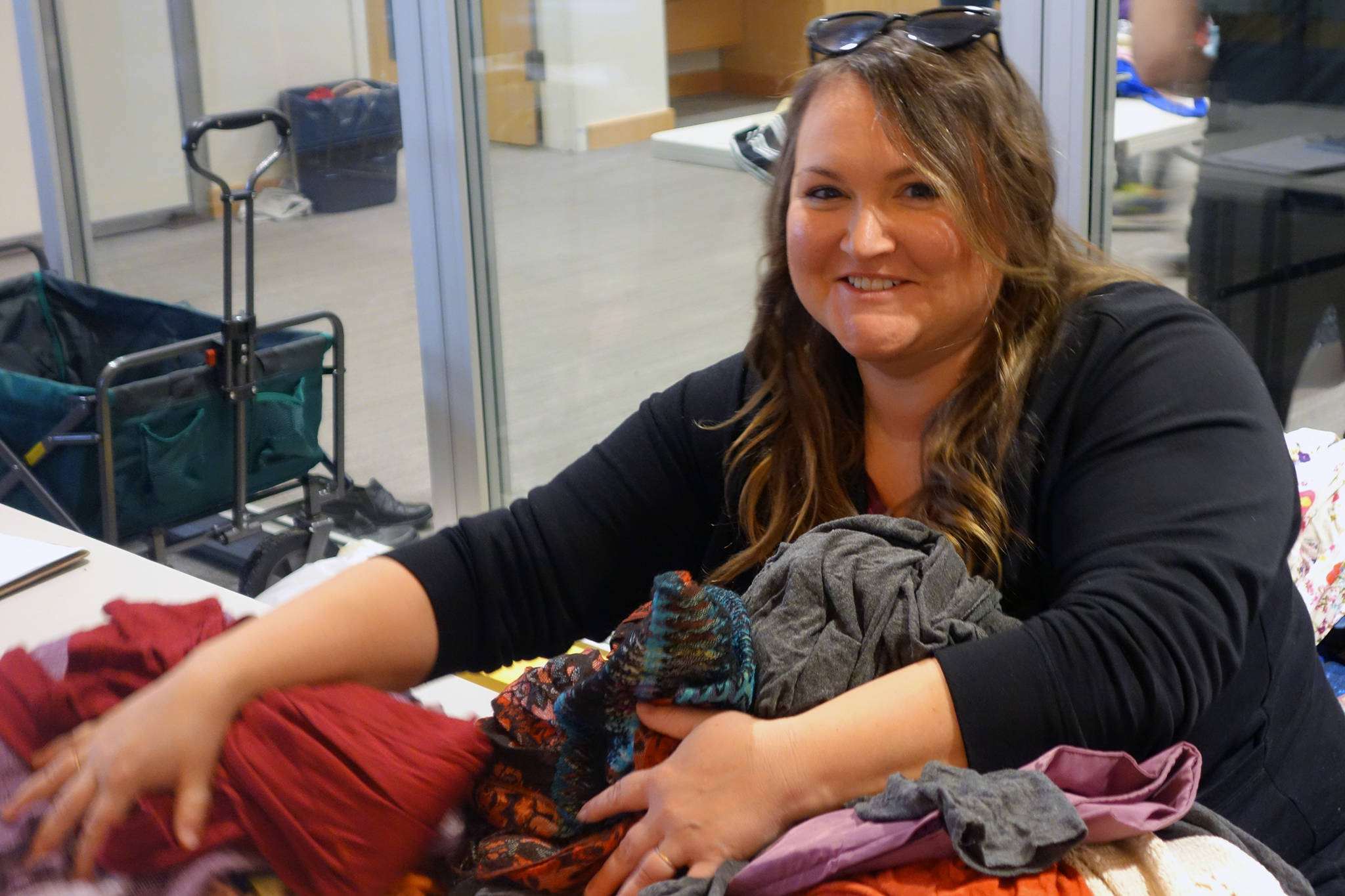 Swap co-organizer Miranda McCarty moves a pile of clothing to be processed by volunteers at the community clothing swap Saturday, Nov. 9. (Ben Hohenstatt | Juneau Empire)
