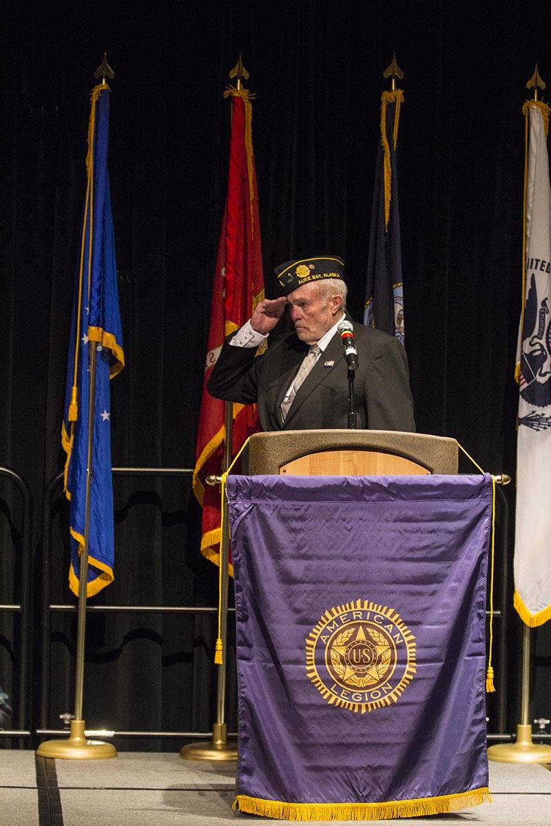 John D. Cooper, commander of the American Legion Auke Bay Post 25, salutes the flag as the colors are presented during a Veterans Day ceremony in Centennial Hall, Nov. 11, 2019. (Michael S. Lockett | Juneau Empire)