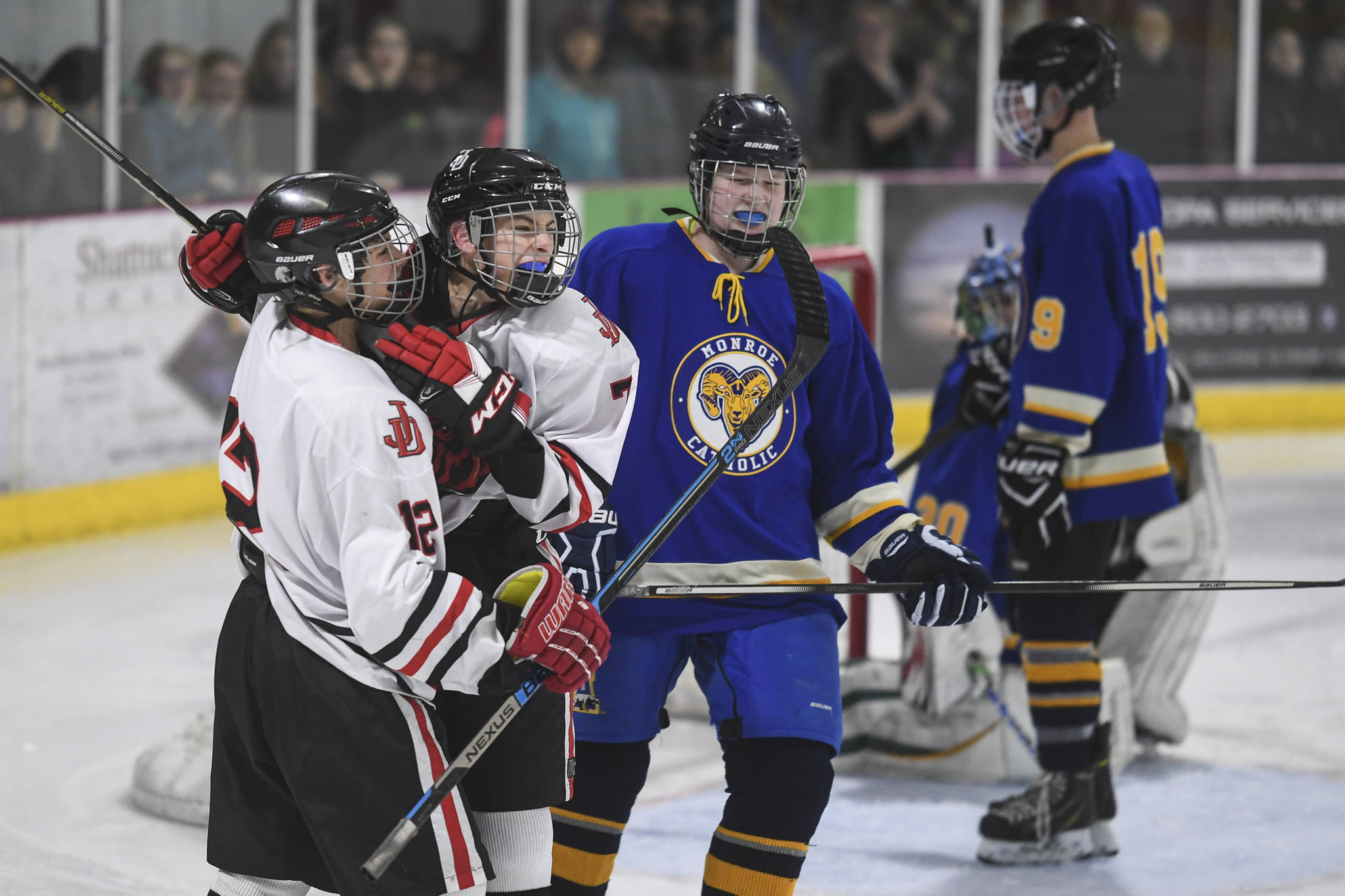 Juneau-Douglas’ Fin Shibler, second from left, celebrates his third period goal with teammate Joey Meier against Monroe Catholic at the Treadwell Arena on Friday, Nov. 15, 2019. JDHS won 13-0. (Michael Penn | Juneau Empire)