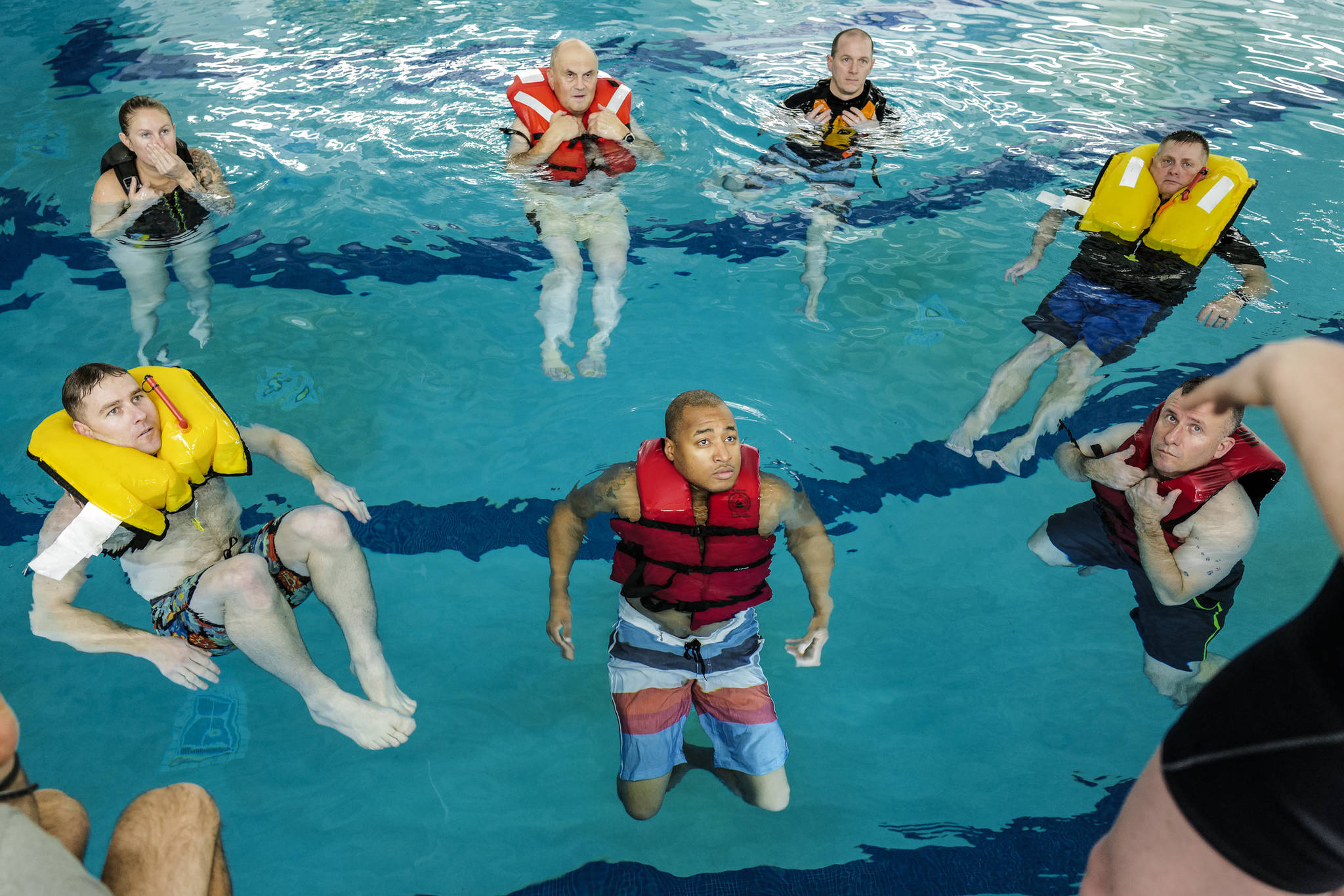Members of the U.S. Coast Guard stationed in Juneau take a boating safety training class at the Augustus Brown Swimming Pool on Tuesday, Nov. 19, 2019. The class will qualify the members to teach students around the state about the use and importance of life vests. (Michael Penn | Juneau Empire)