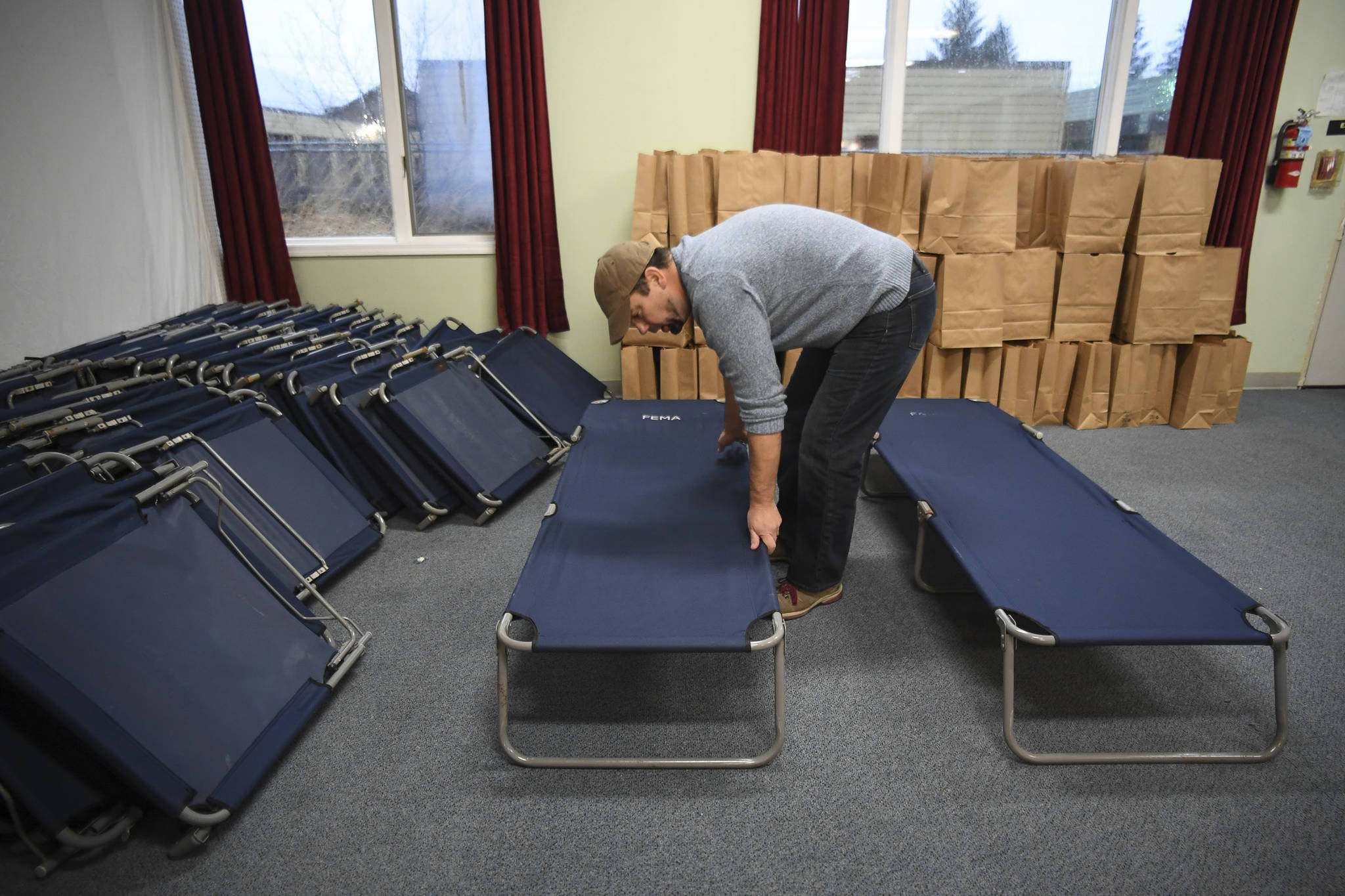 Cold Weather Emergency Shelter Manager Richard Cole set up cots at St. Vincent de Paul on Wednesday, Nov. 20, 2019. The shelter is expected to open Saturday. (Michael Penn | Juneau Empire)